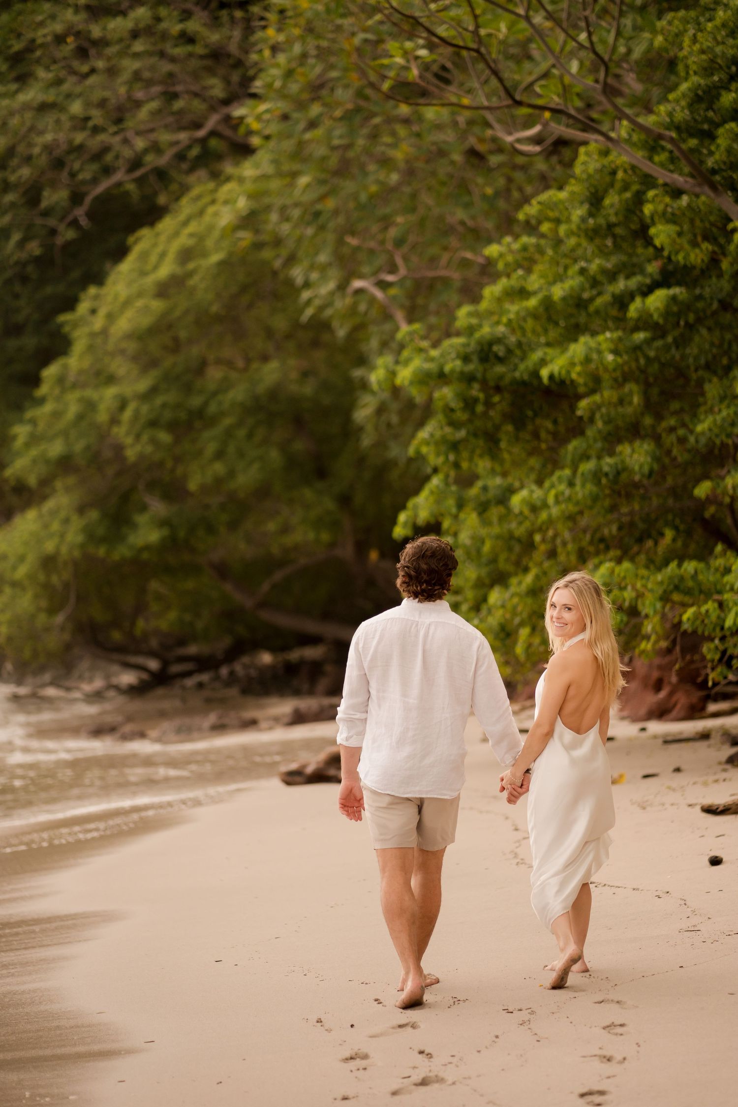 Couple walking hand in hand along Flamingo Beach during a relaxed romantic photography session in Guanacaste, Costa Rica.