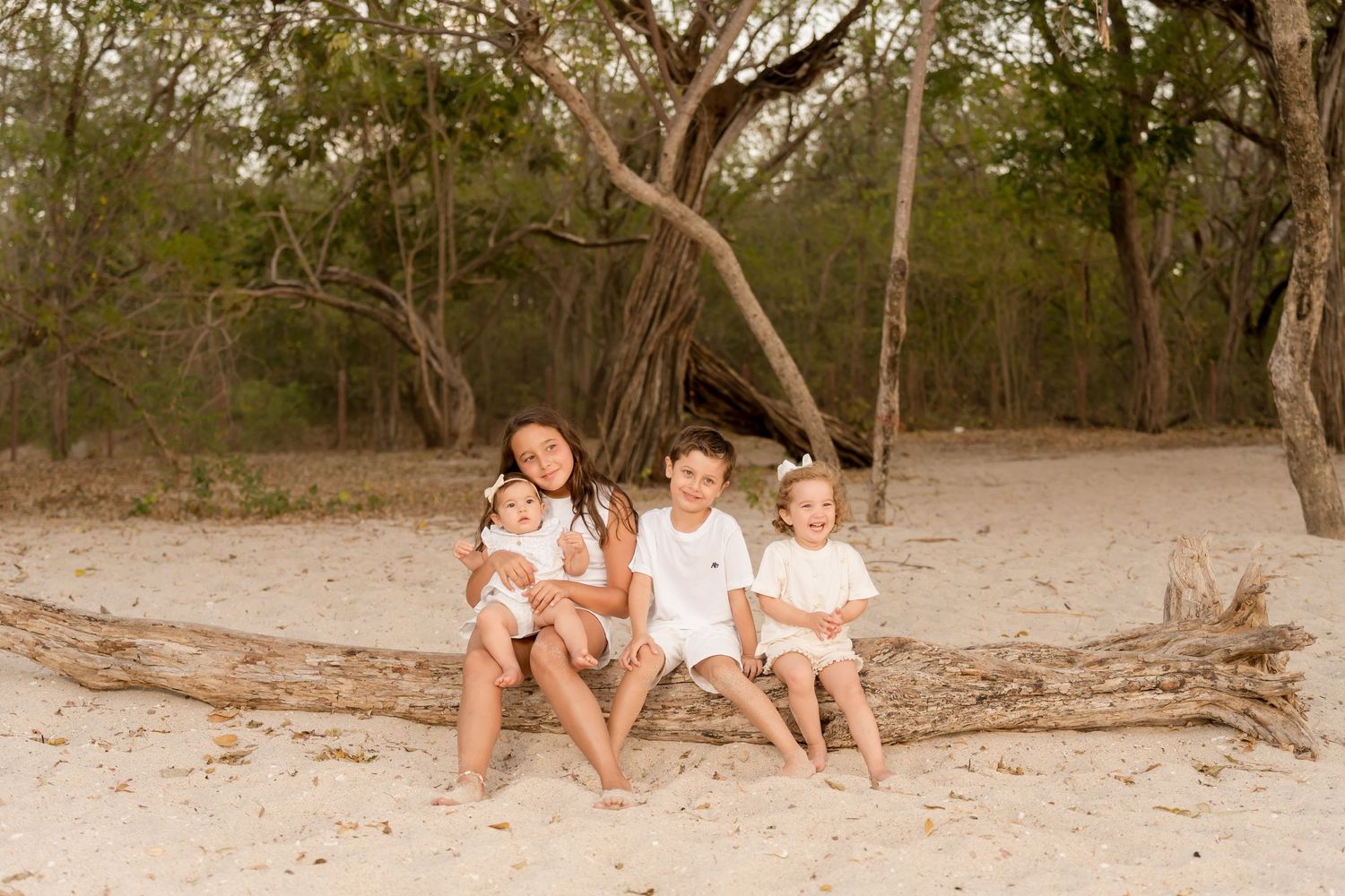 Mother and children sitting together on the beach during a family photography session at Playa Conchal, Costa Rica