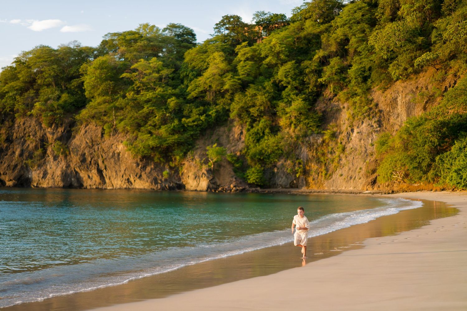 Child playing along the shoreline during a beach family photography session in Peninsula Papagayo, Costa Rica.