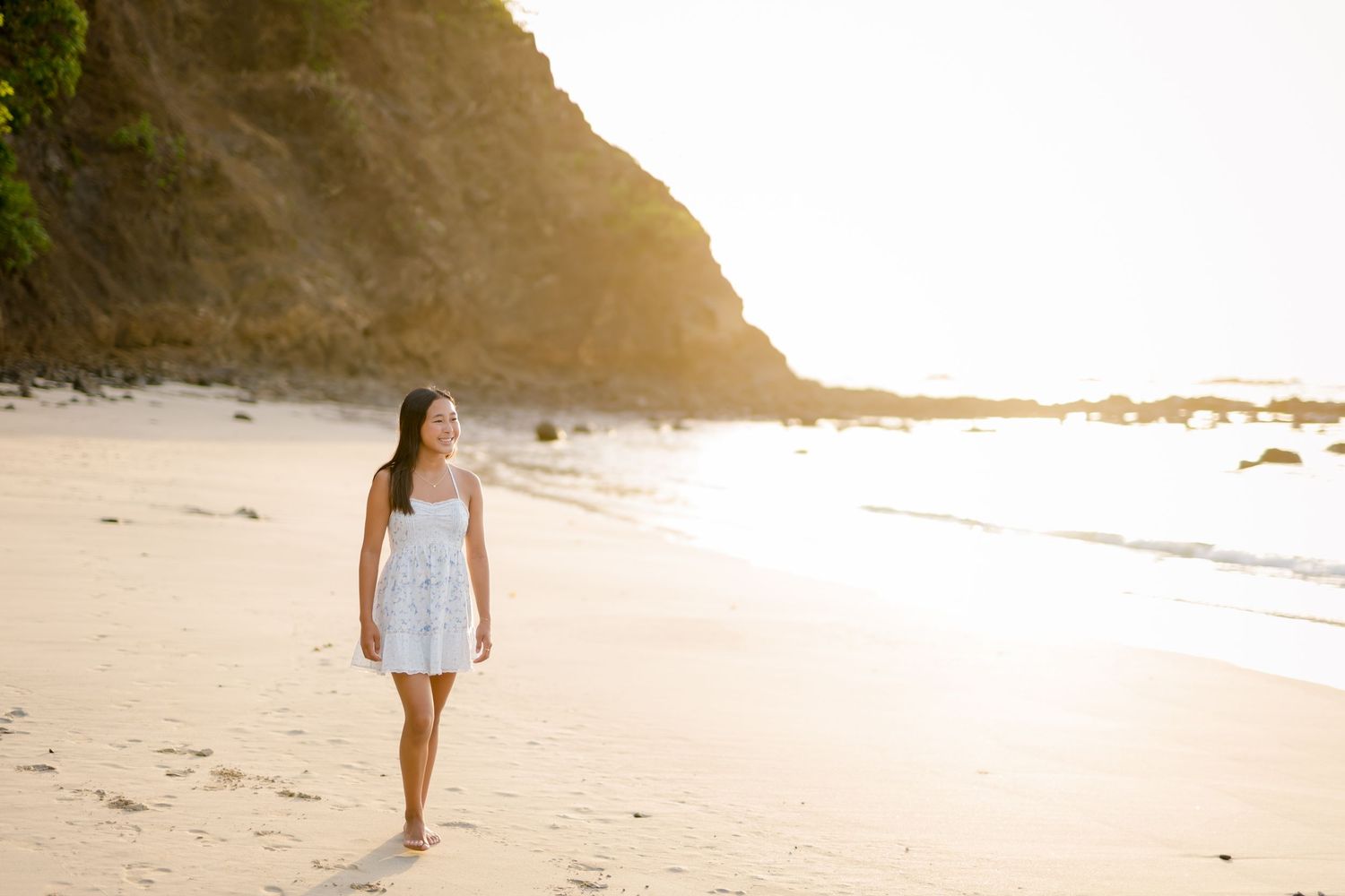 Girl walking along the beach in golden sunset light during a family session at Four Seasons Peninsula Papagayo, Costa Rica.
