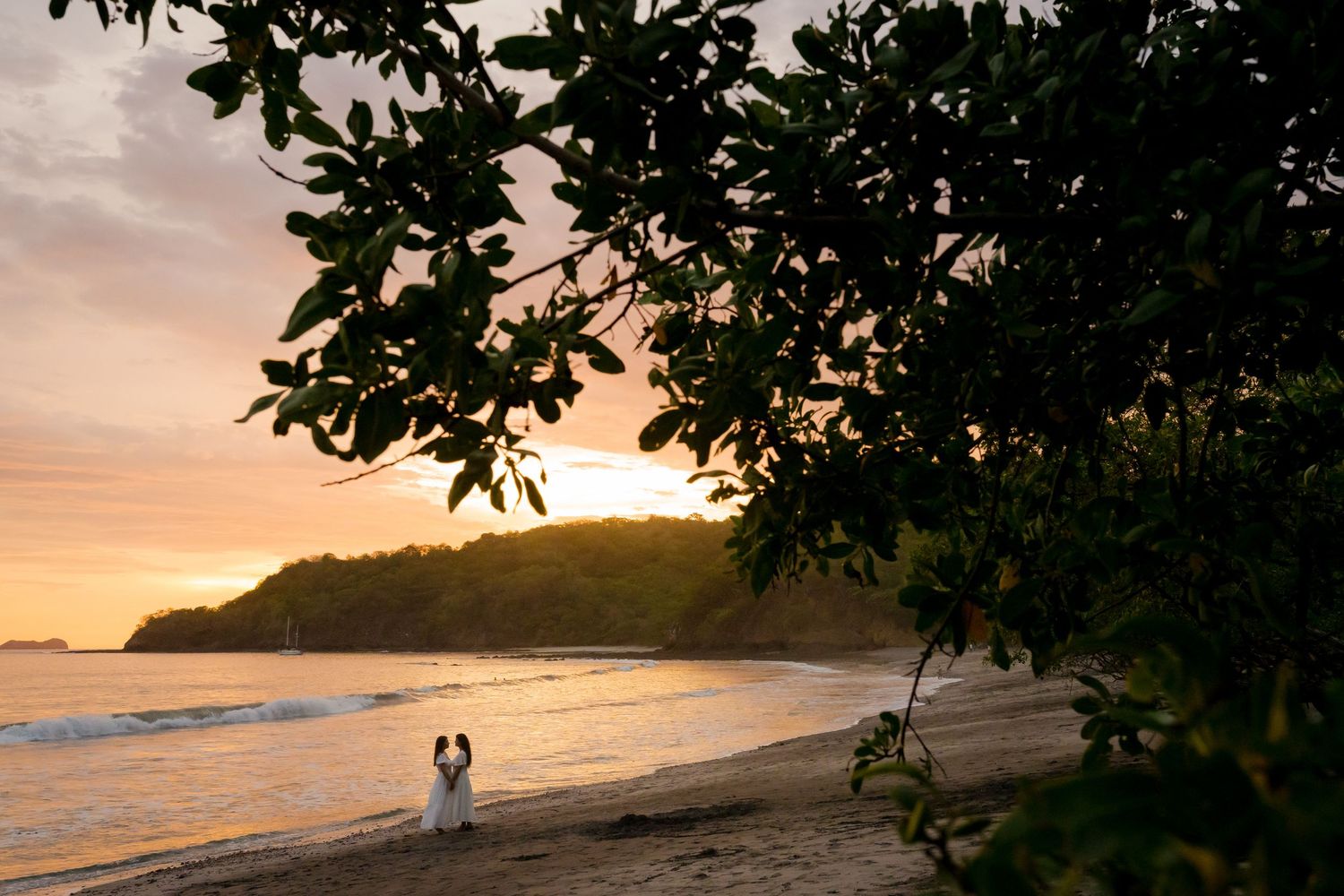 Couple walking along the beach at sunset during a romantic photography session near Las Catalinas in Guanacaste, Costa Rica.