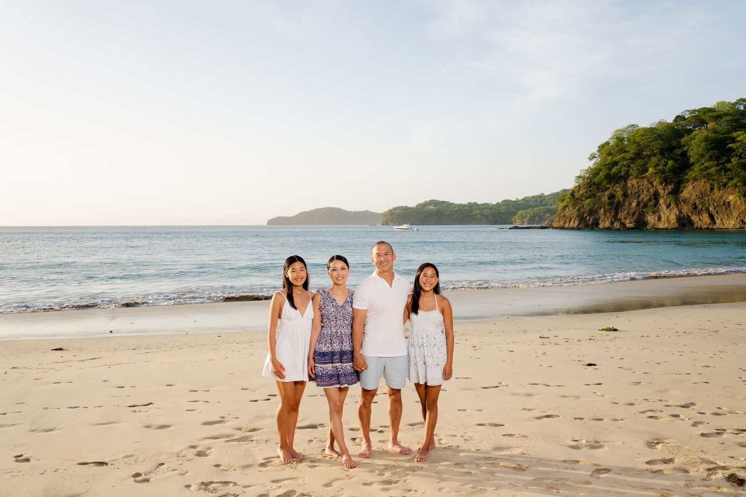 Family of four posing together on the beach during their vacation at Four Seasons Peninsula Papagayo, Costa Rica