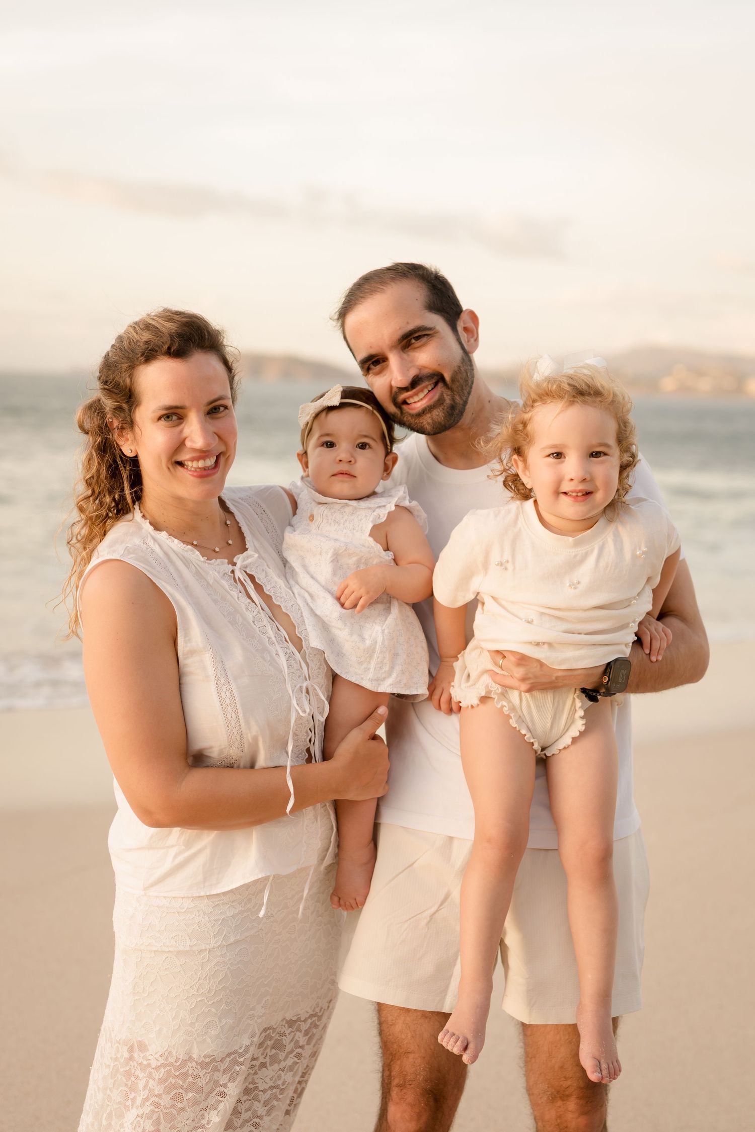 Father sharing a sweet moment with his young daughters during a family beach session at Playa Conchal.