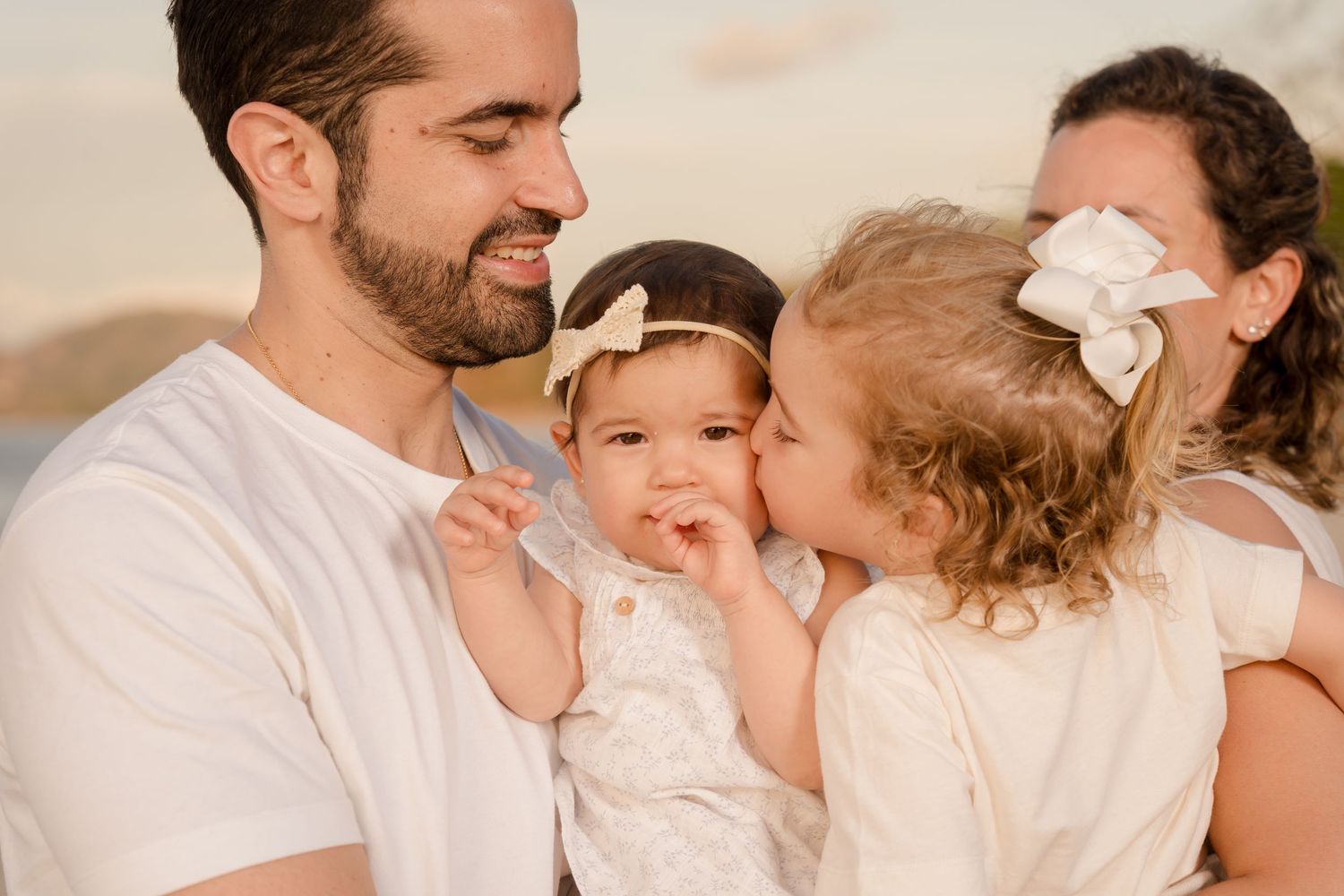 Mother and father with their young children during a family portrait session at Playa Conchal, Guanacaste.