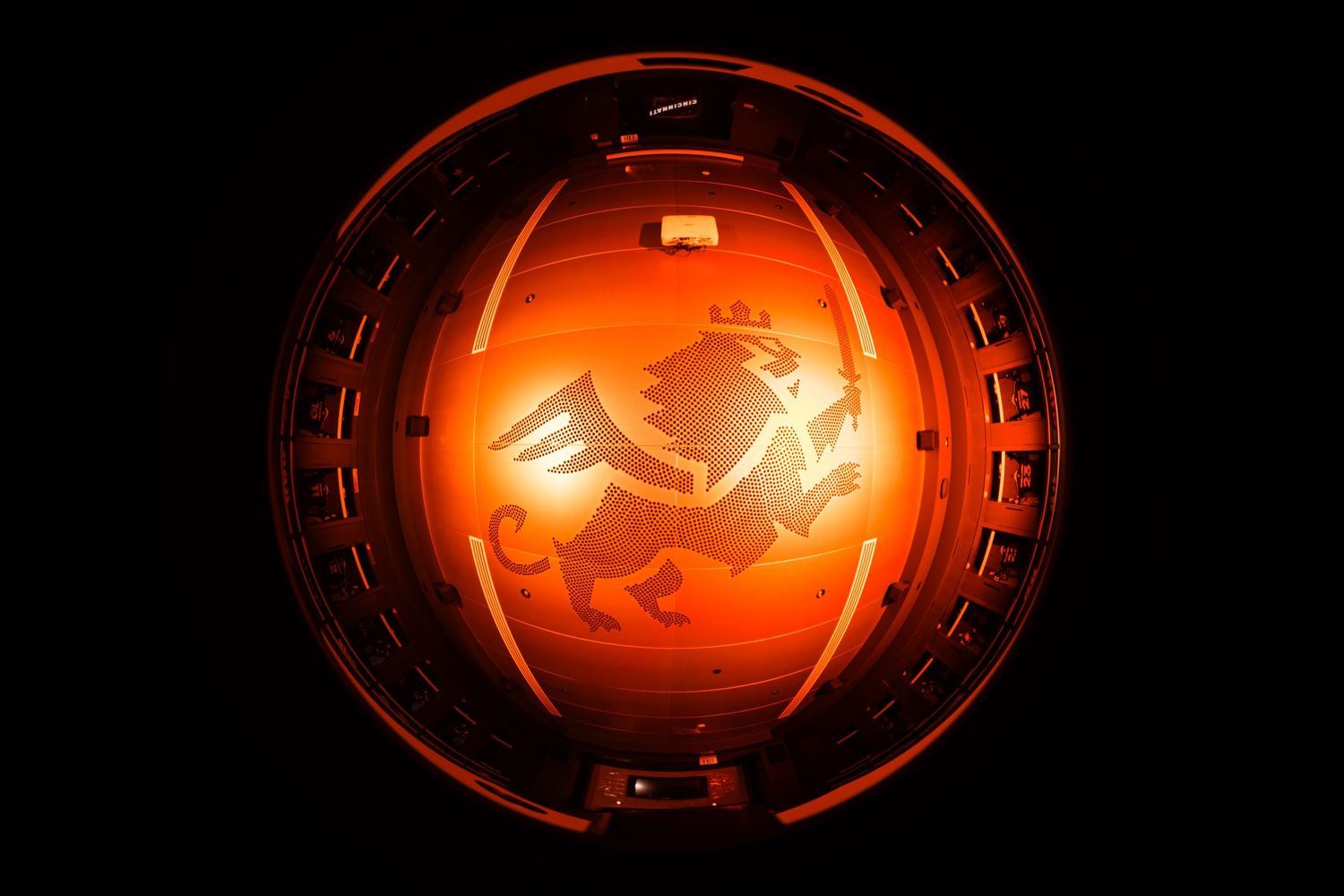 Wide-angle view of an illuminated FC Cincinnati lion graphic displayed on a circular interior ceiling.
