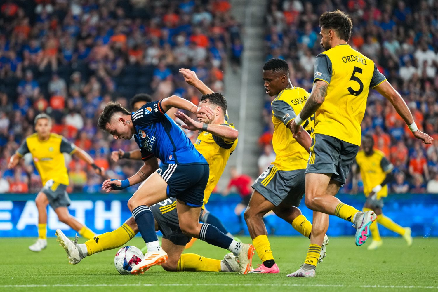 Soccer players competing for the ball during a match between FC Cincinnati and Pittsburgh Riverhounds.