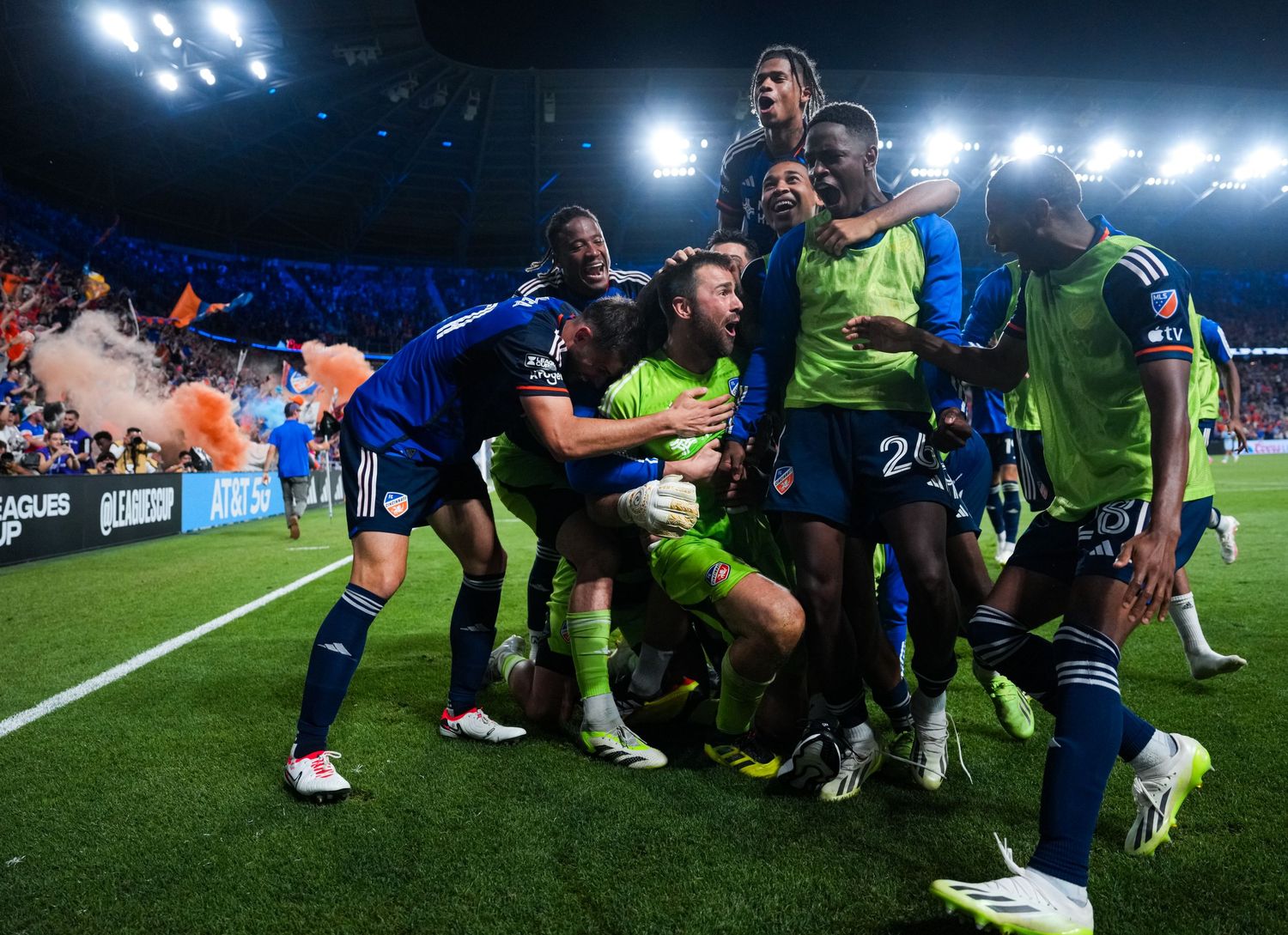 FC Cincinnati players celebrating on the field after a match with fans visible in the background.