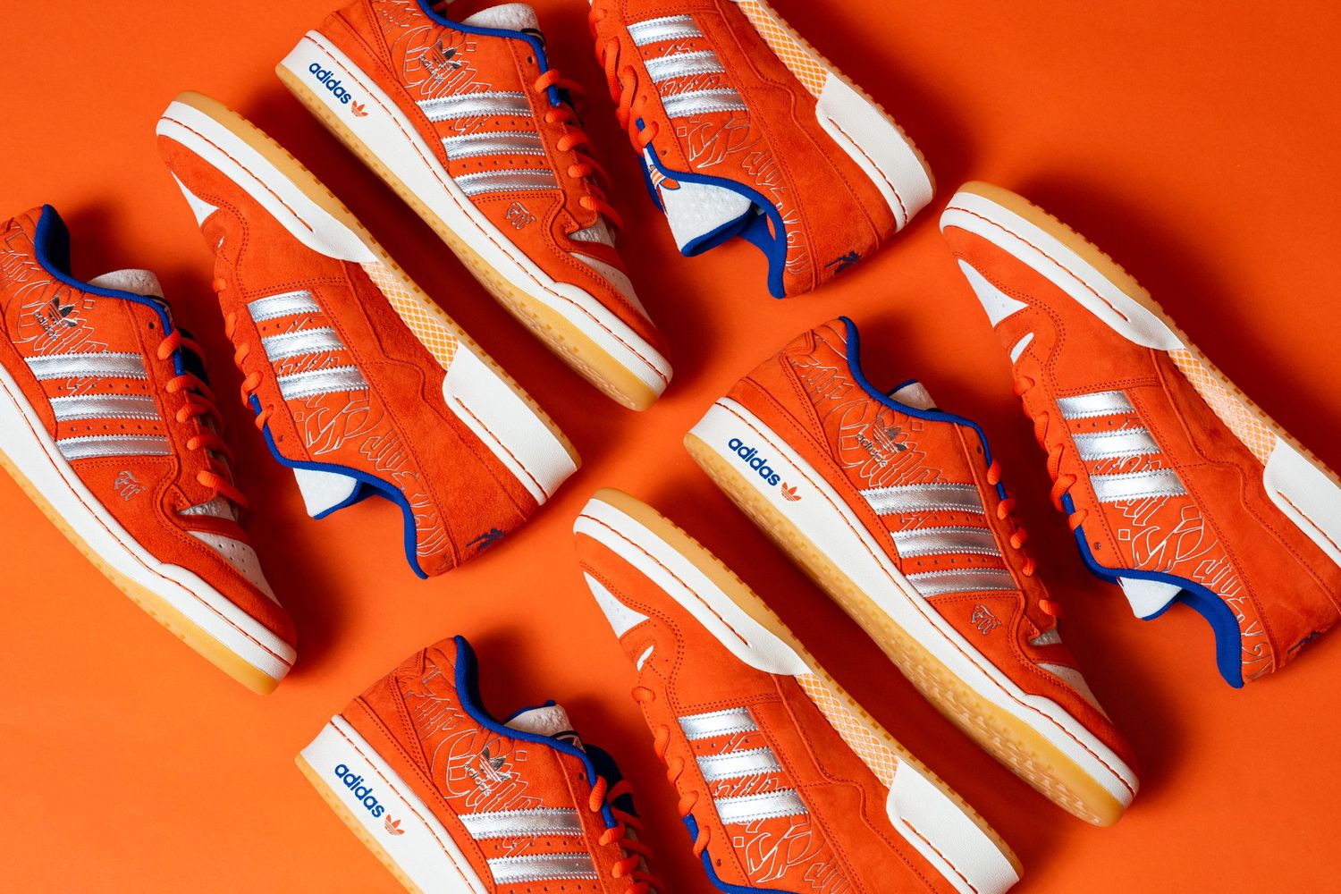 Multiple orange Adidas sneakers arranged in a repeating flat-lay pattern on an orange background.