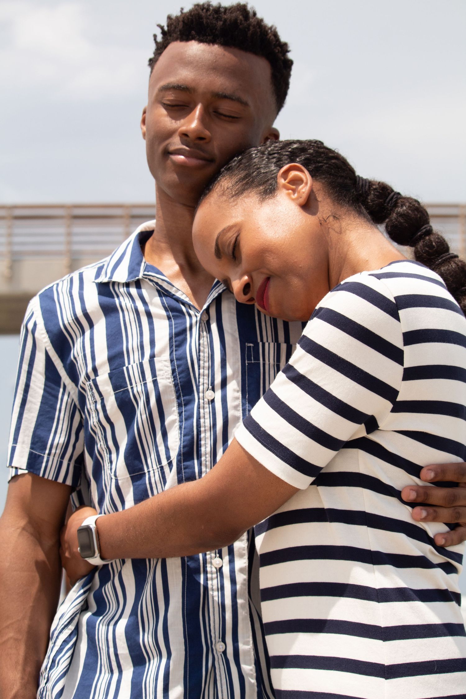Mother and son embracing in matching navy and white striped outfits, close family connection portrait