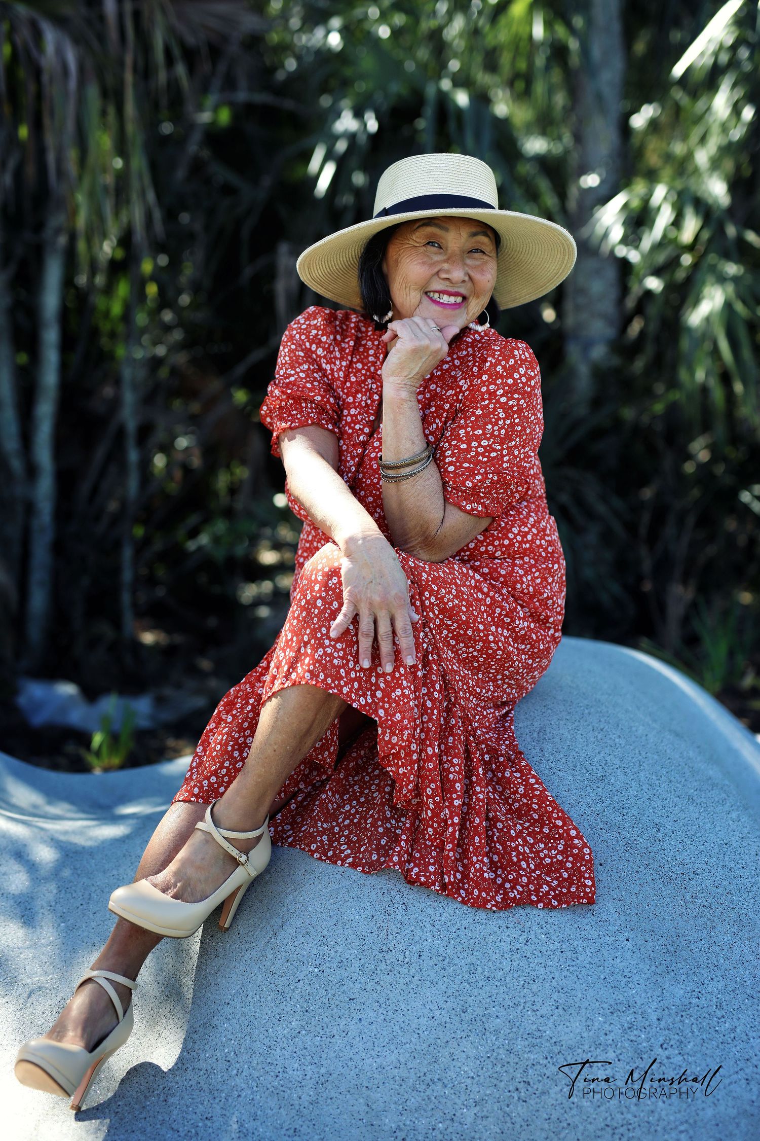 Older woman in a red floral dress laughing, wide-brim hat, women's portrait in Jacksonville, FL