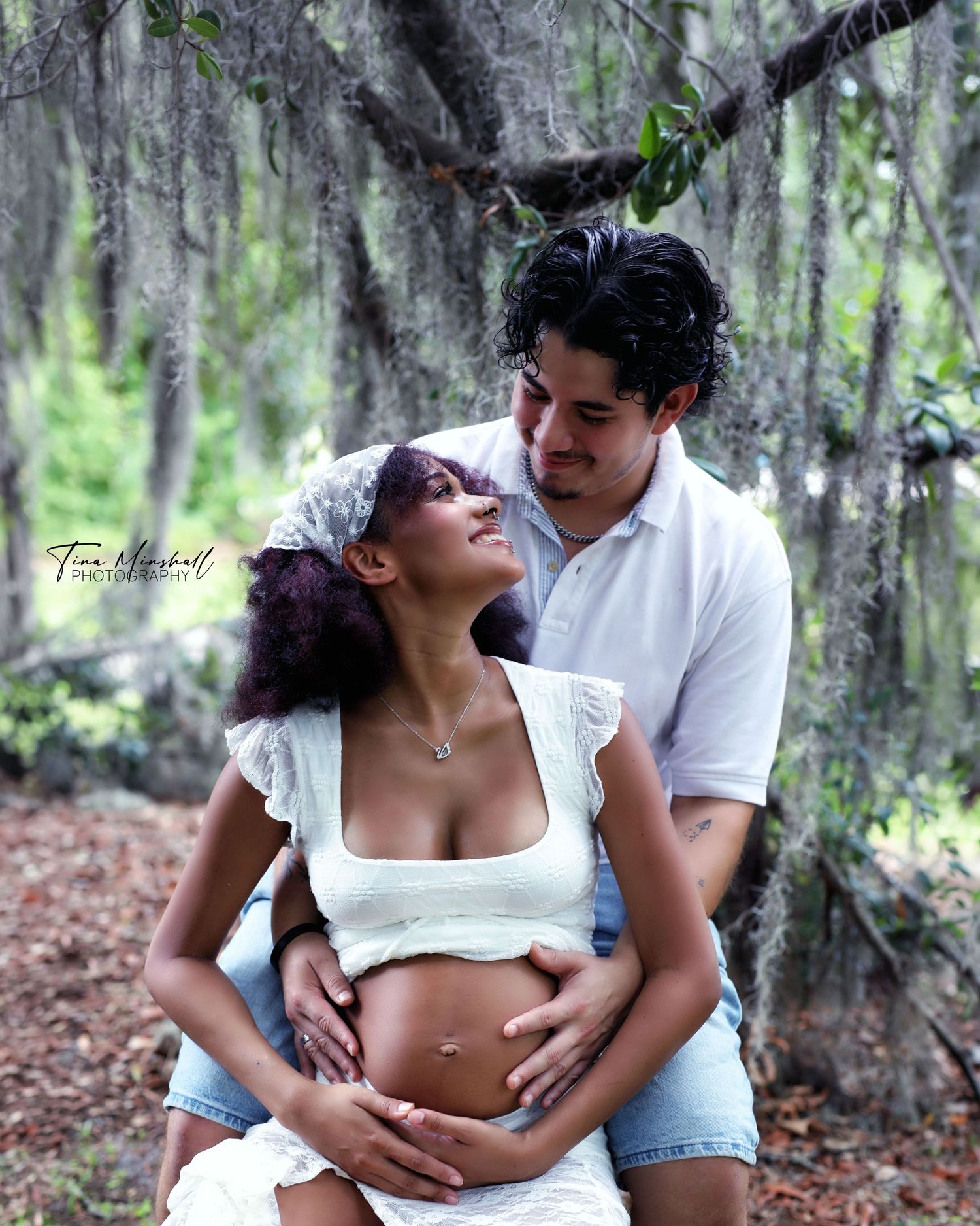Couple laughing together during a maternity session under oak trees, Jacksonville, FL