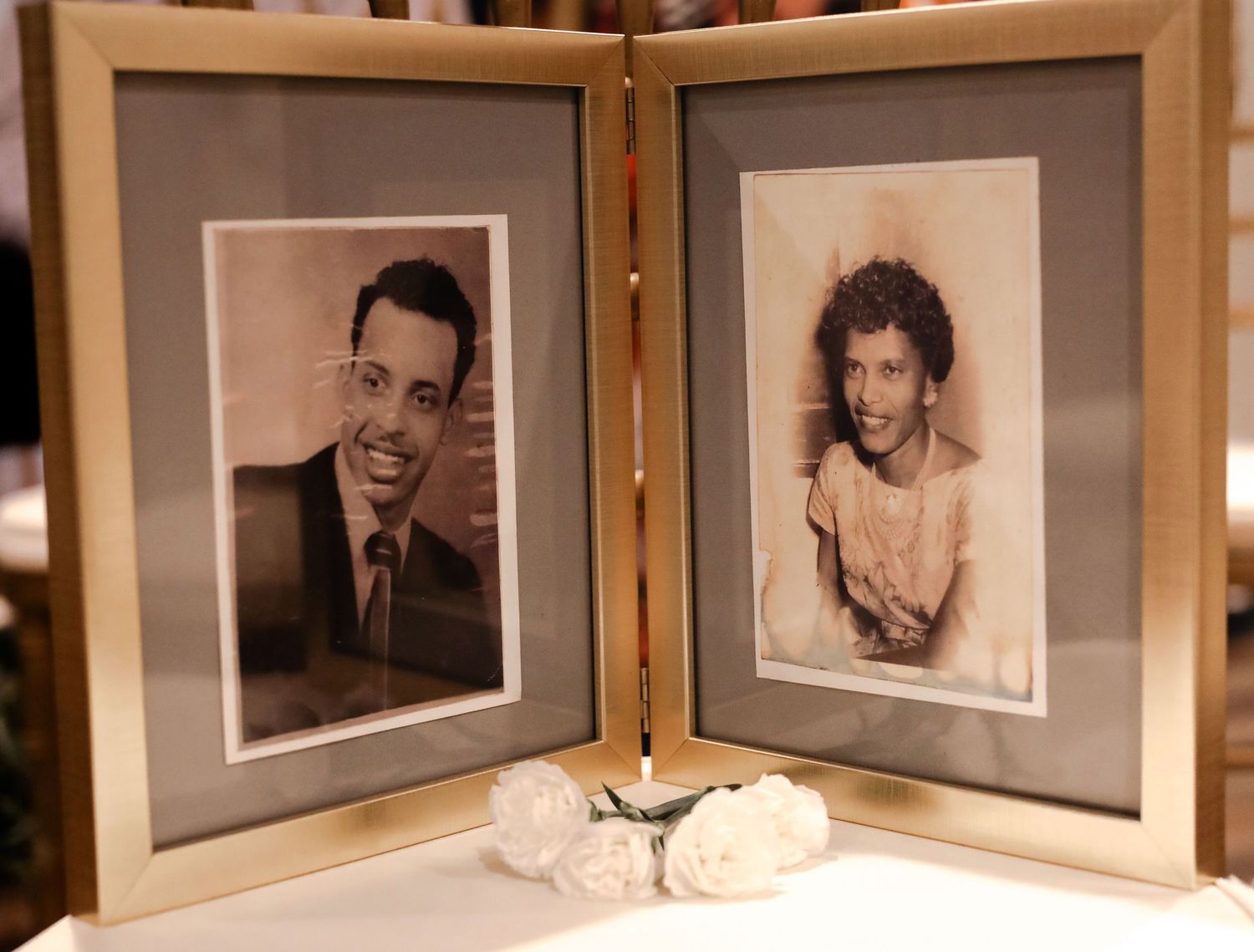 Two vintage sepia photographs of a young man and woman displayed in an open frame