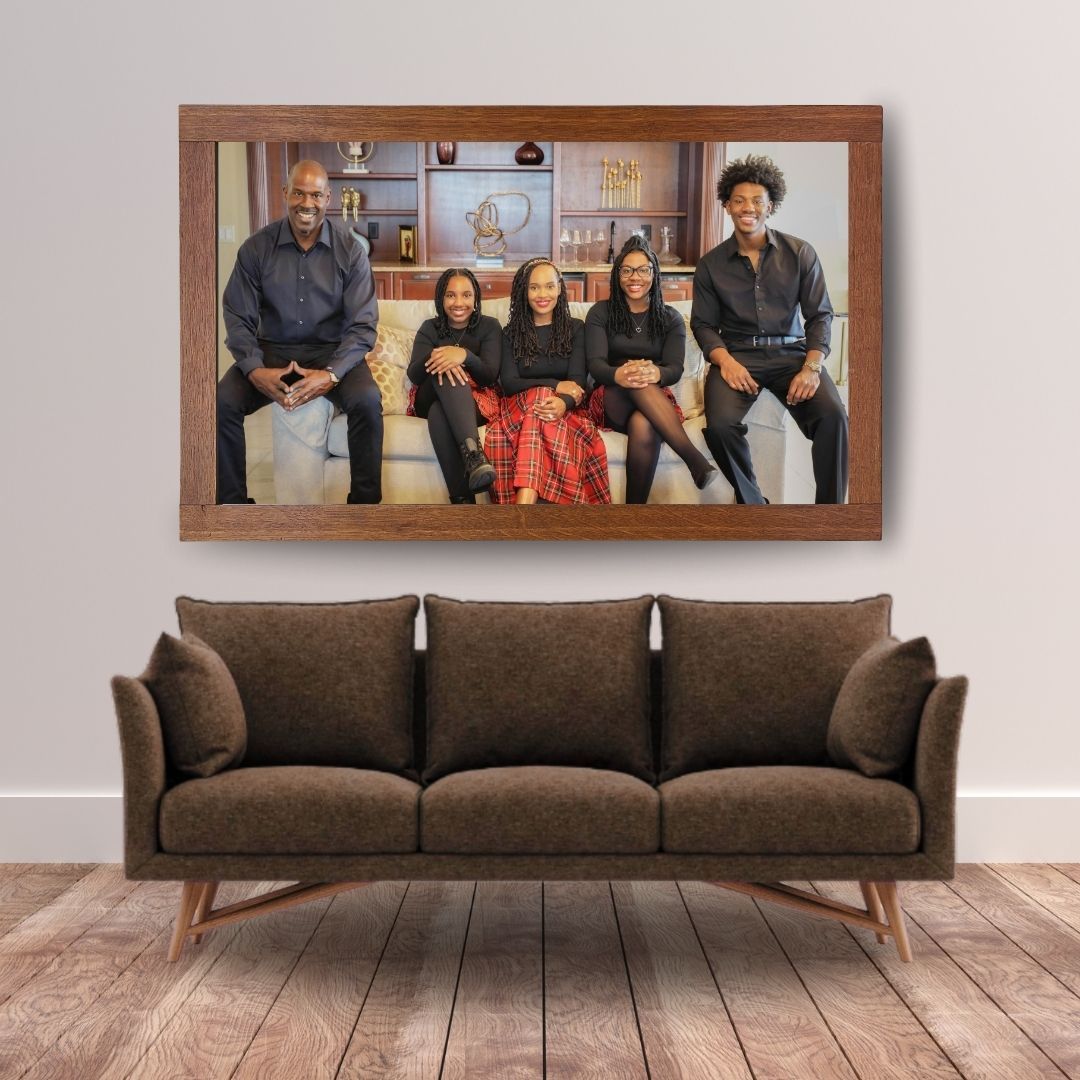 Framed family portrait of five people smiling together on a couch, multigenerational family photography Jacksonville.