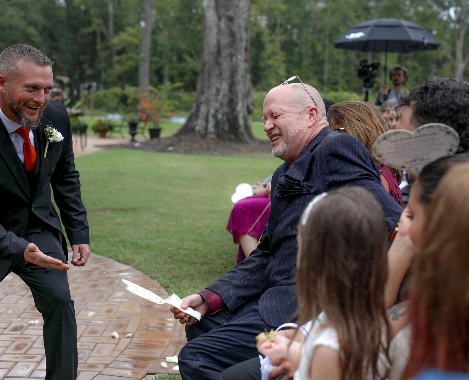 Groom laughing with a wedding guest, candid unscripted moment
