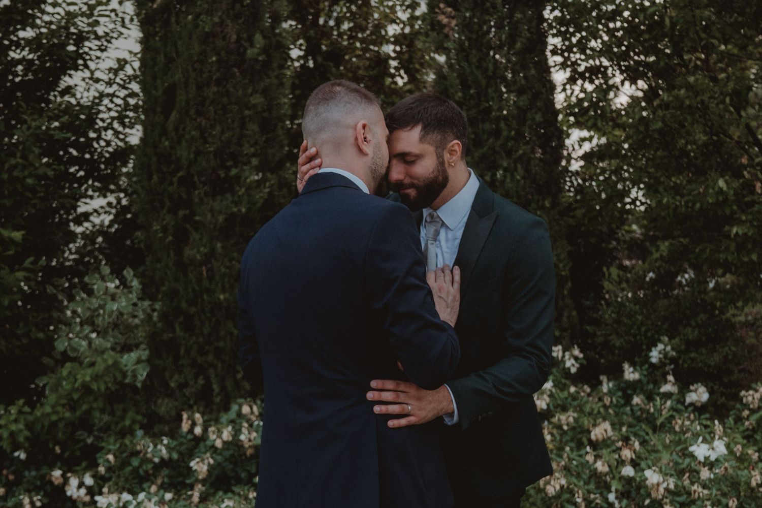 Married couple sharing a tender kiss on the forehead.