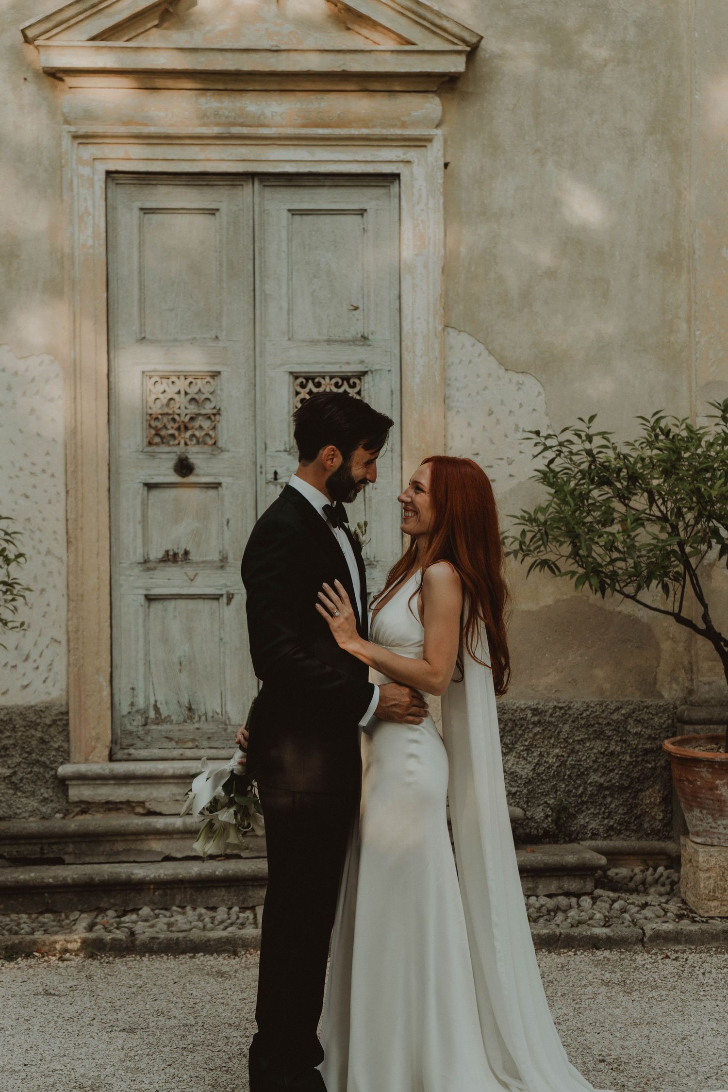 Newlywed couple kissing at a historic villa in Verona, Italy, with a beautiful sunset in the background.
Questa secondo me funziona molto be