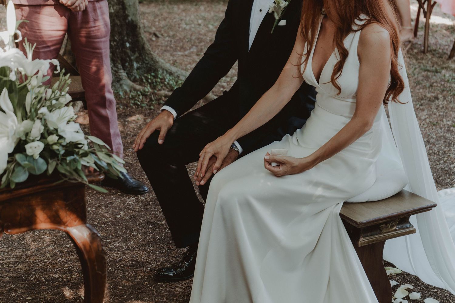 In questo caso, visto che non abbiamo una location specifica, lo terrei semplice:

Newlywed couple sitting together and holding hands on the