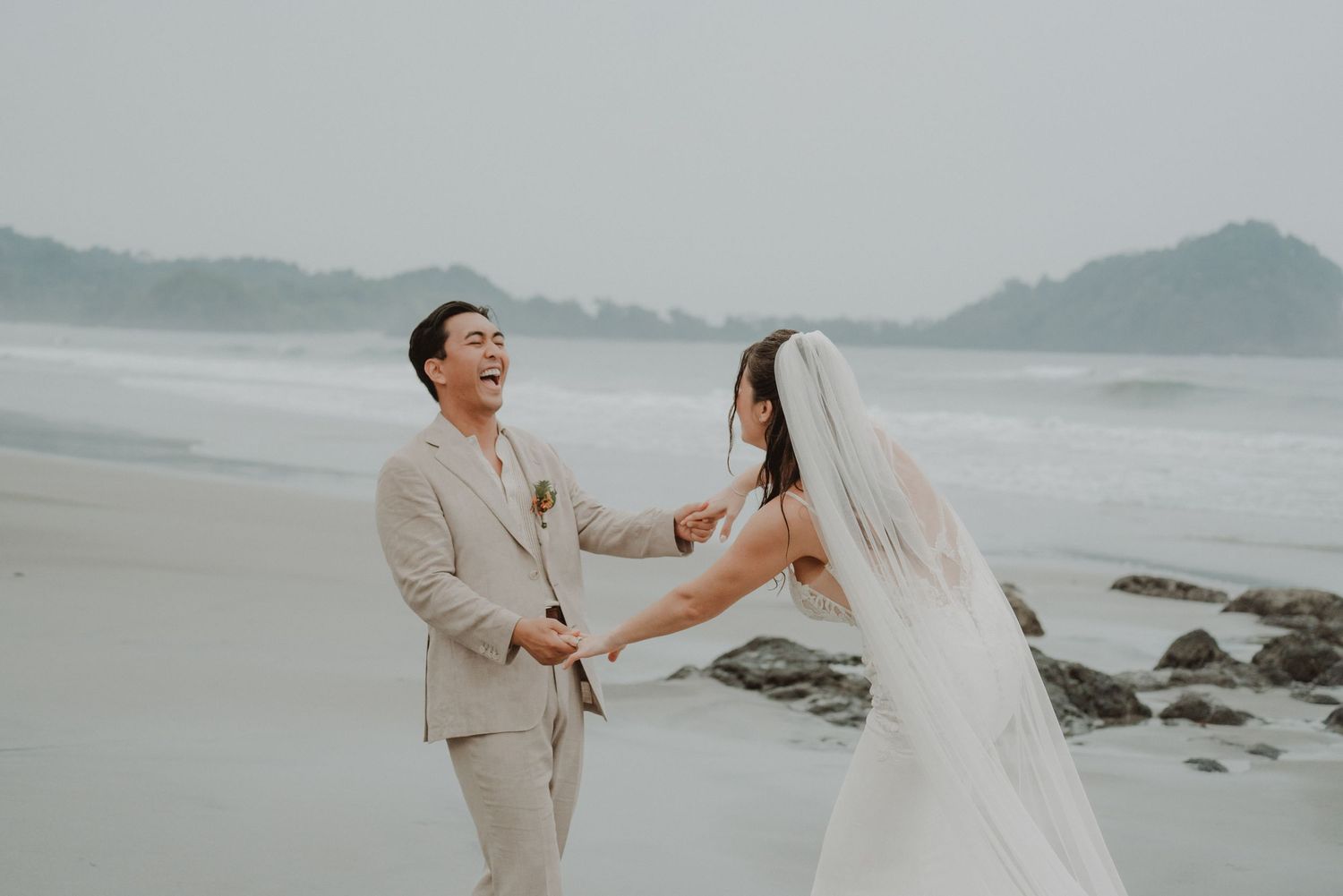 Newlywed couple running together along the beach on their wedding day in Costa Rica.
