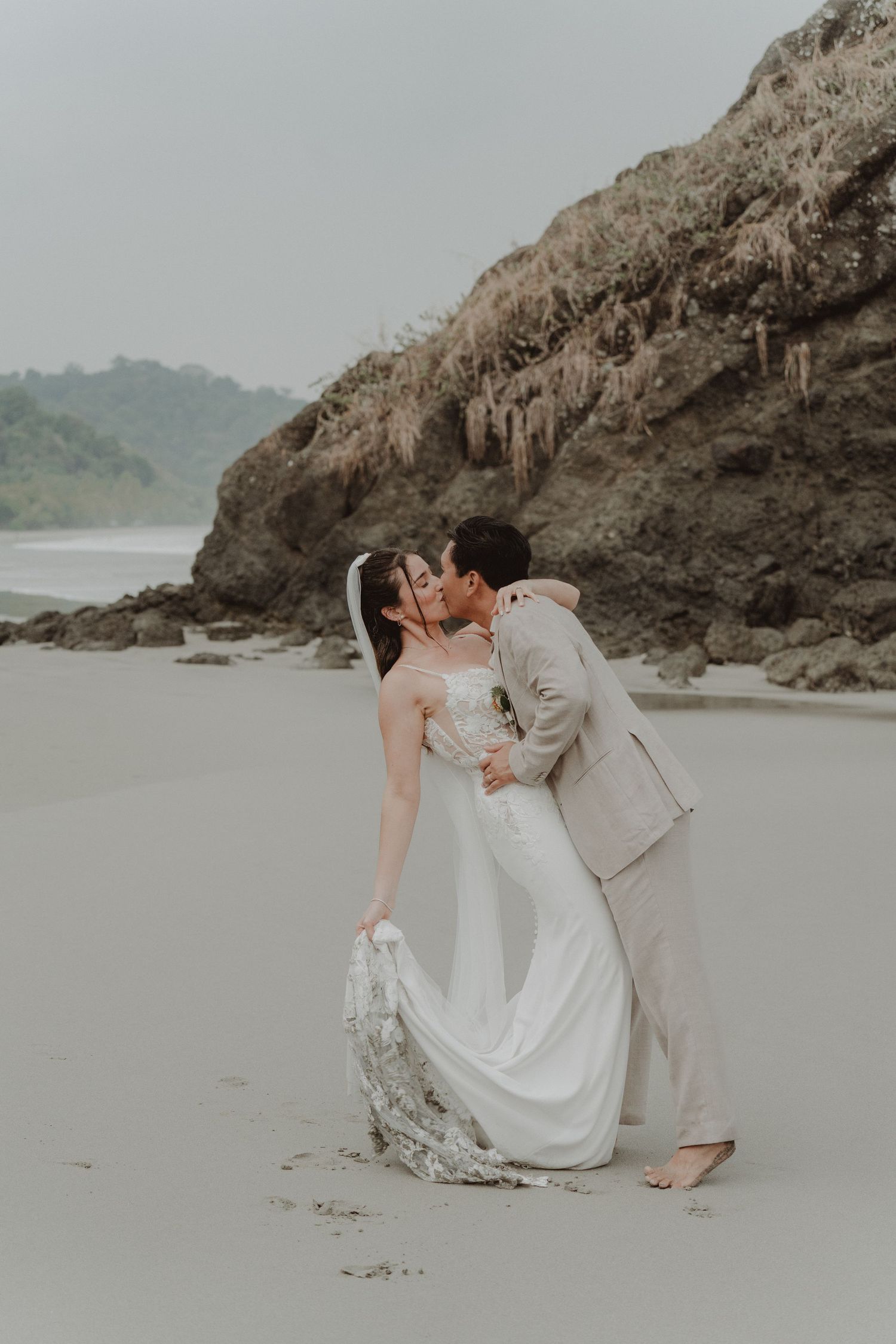 Newlywed couple kissing on a beach in Costa Rica on their wedding day.