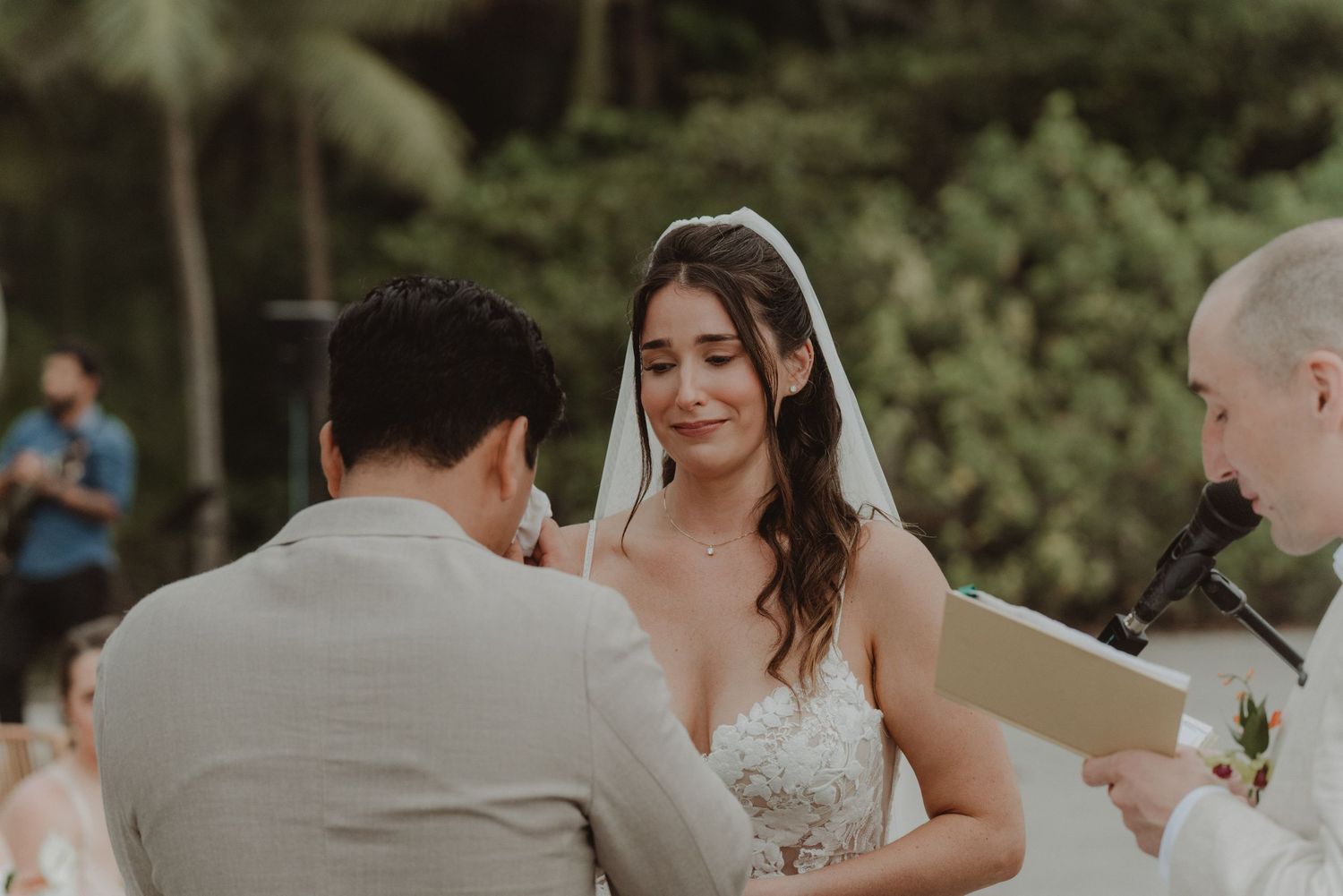 Bride becoming emotional as she watches her groom tear up during their wedding ceremony.