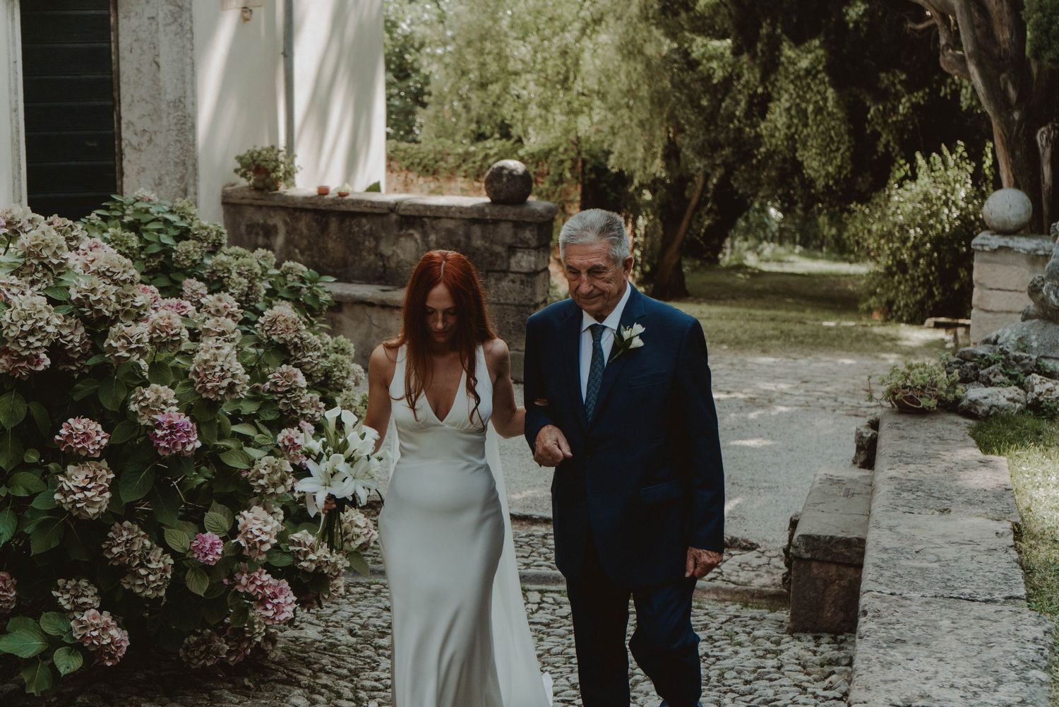 Bride walking down the aisle with her father at a wedding ceremony in a historic villa in Verona, Italy.