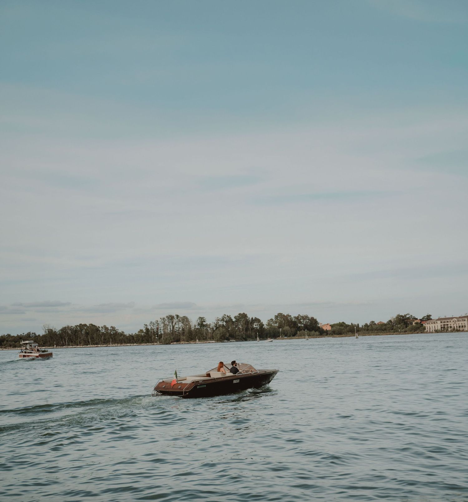 Bride and groom riding a traditional boat through the canals of Venice, Italy, on their wedding day.