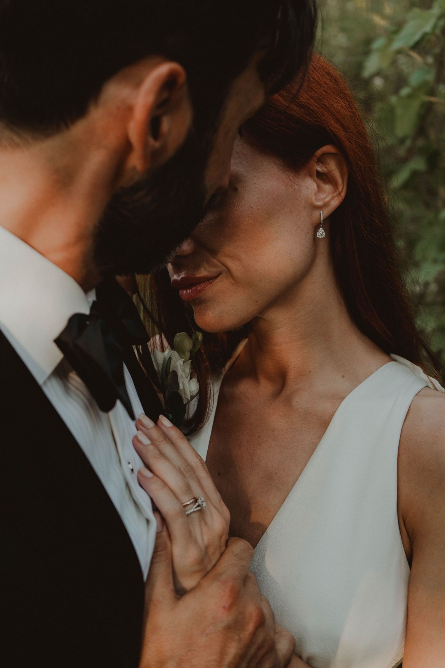Romantic moment between a newlywed couple, with the bride's wedding ring visible.