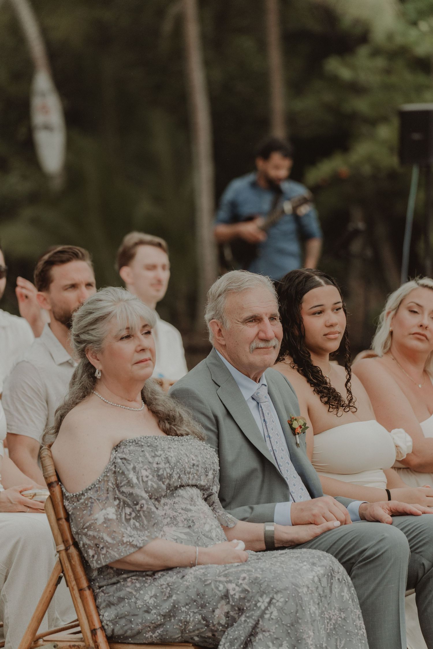 Bride's parents watching the wedding ceremony on the beach.