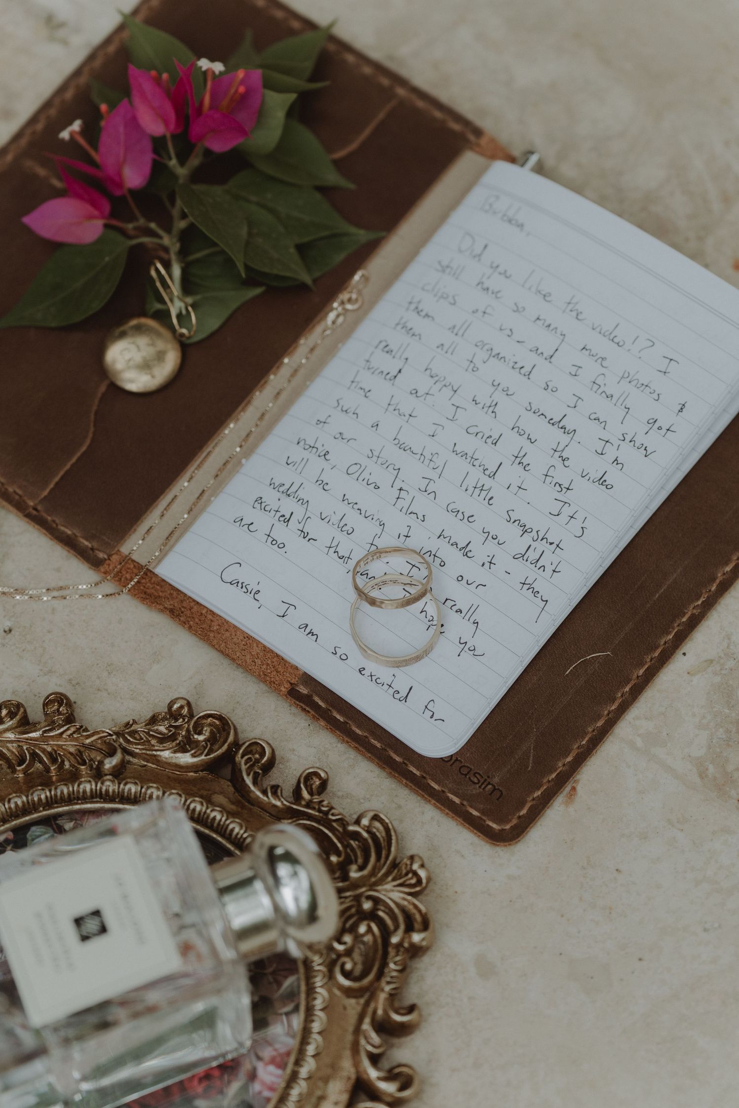 Wedding details including the rings, perfume, and a vow booklet with handwritten promises.