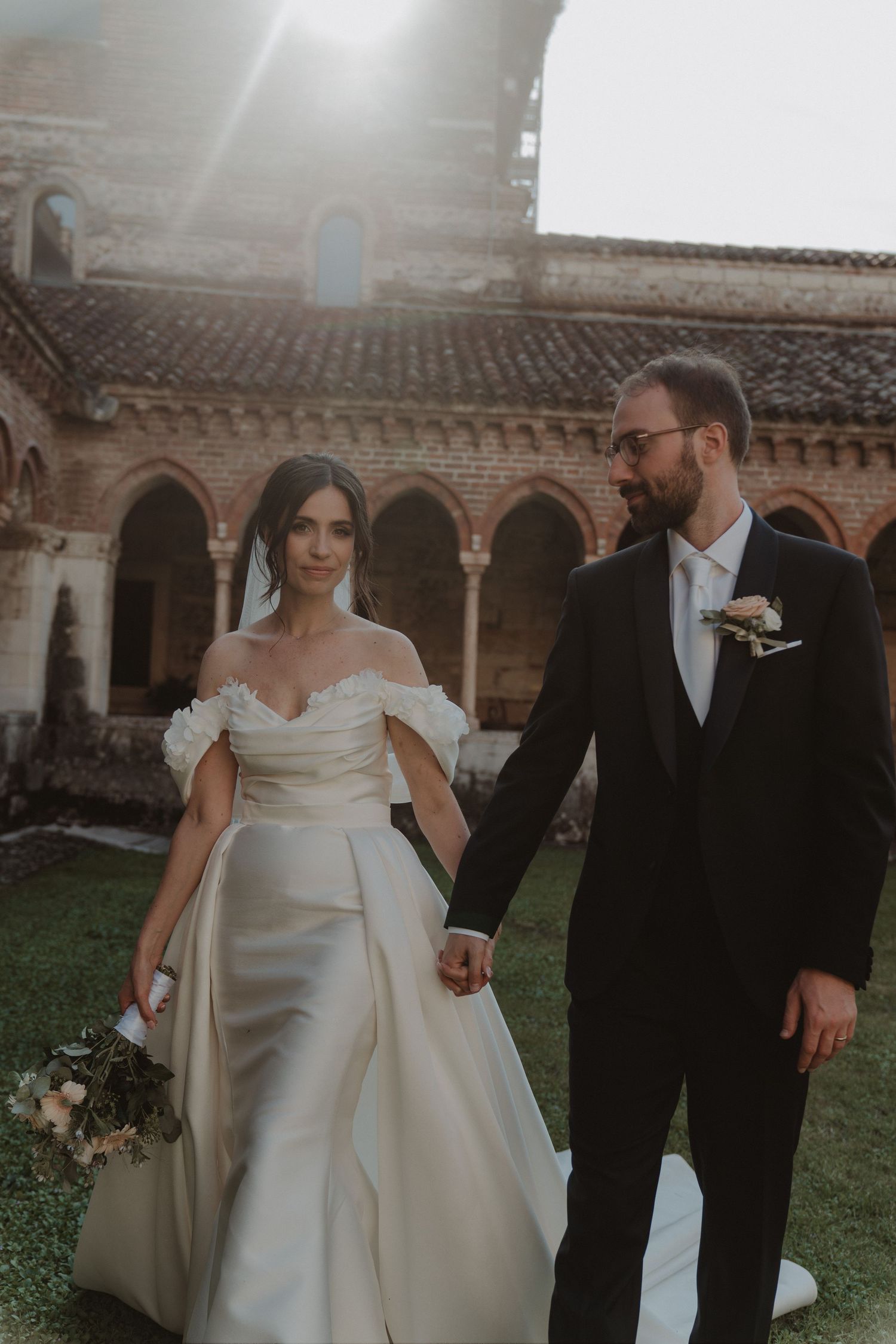 Newlywed couple holding hands inside the Basilica of San Zeno in Verona, Italy.