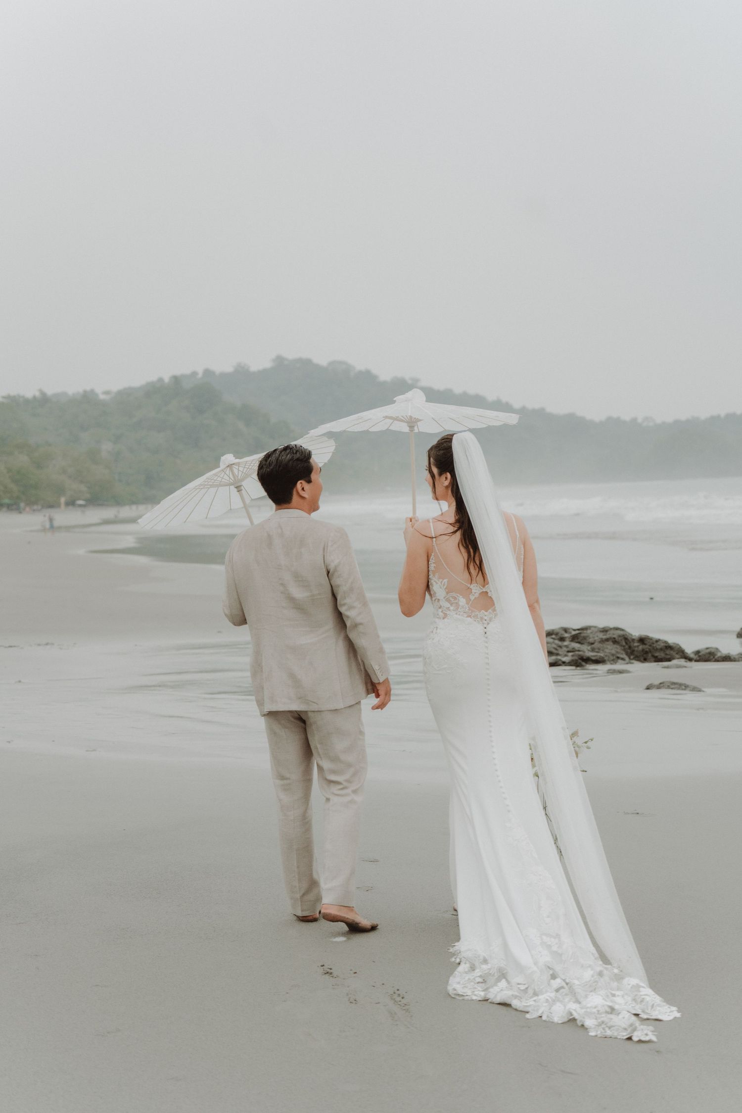 Newlywed couple facing each other and kissing on a beach in Costa Rica.