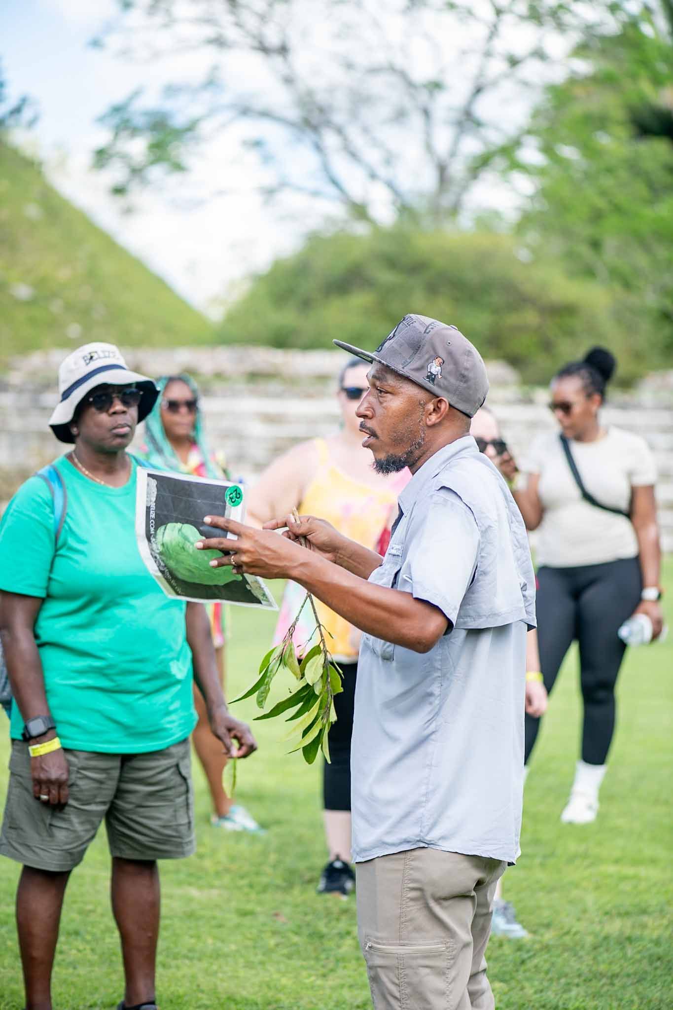 Group of people gathered outdoors at a park event wearing casual attire and engaging in activities.