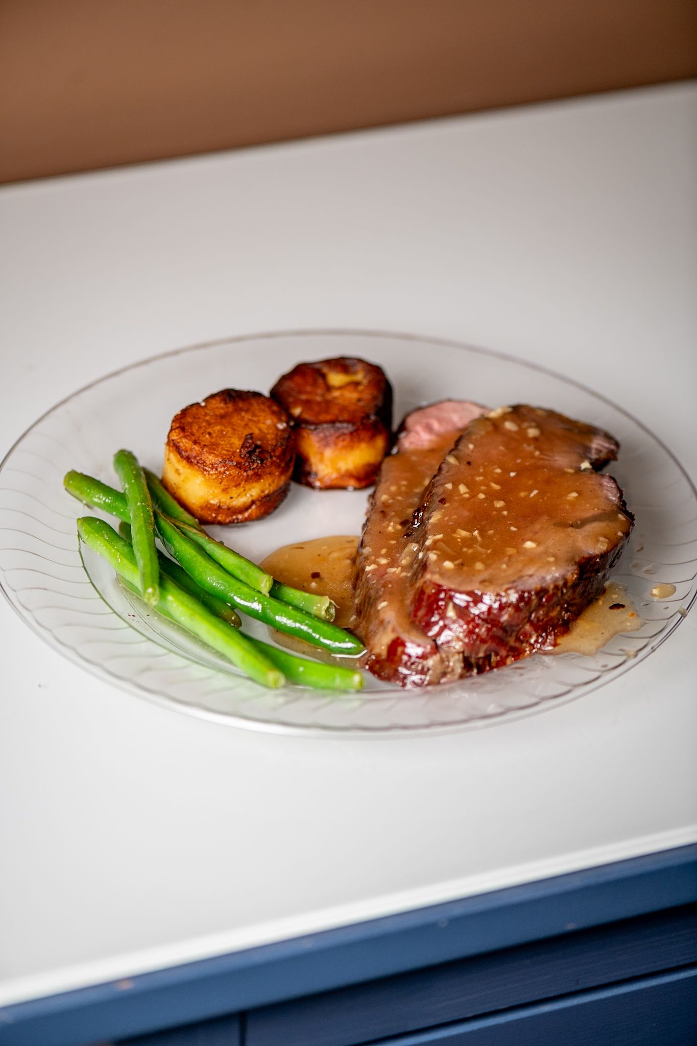 Plated steak dinner with green asparagus and roasted potatoes on a white plate.