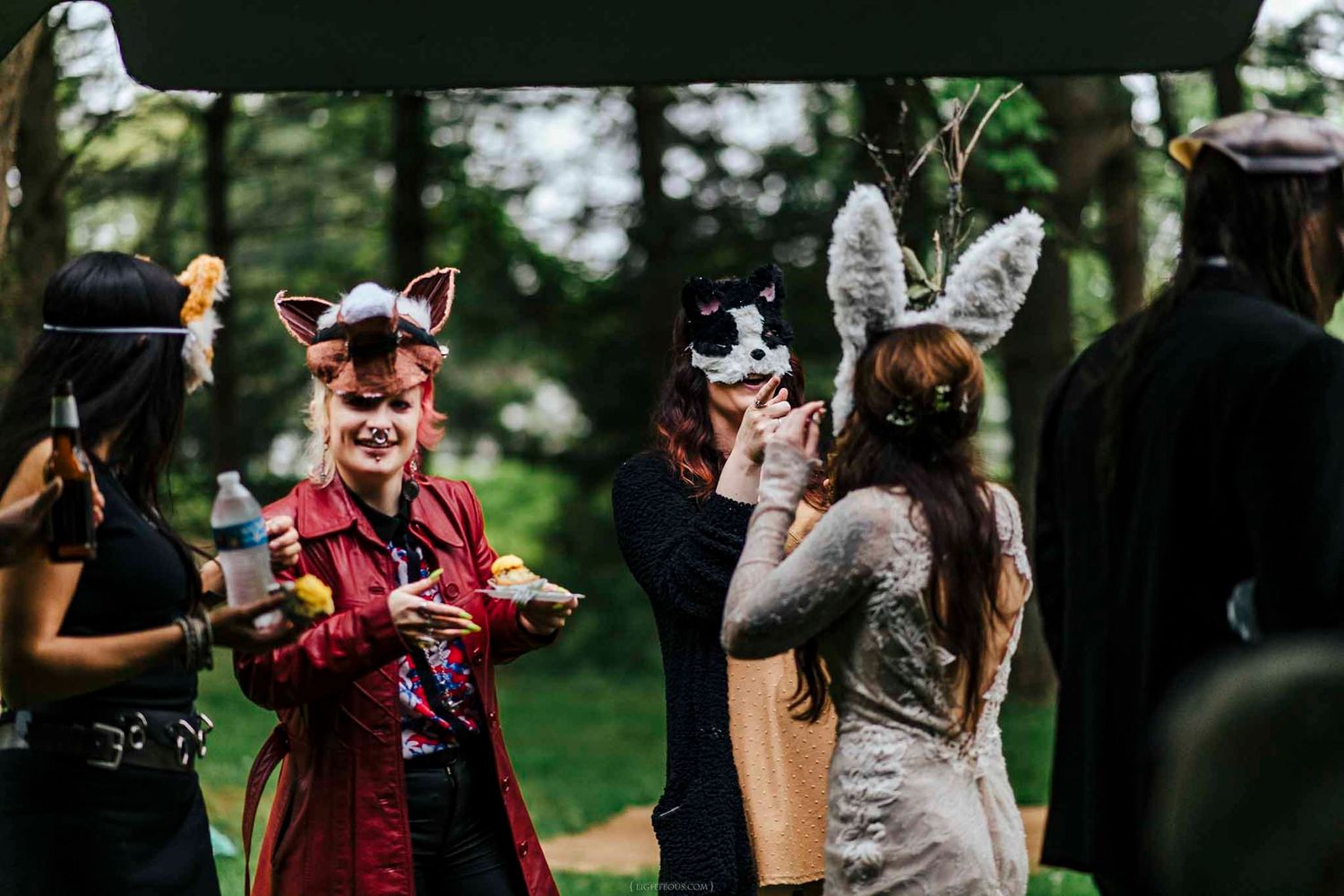 Group of guests wearing animal masks and costumes at an outdoor themed party event.