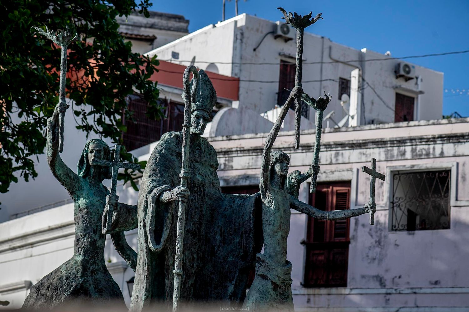 Bronze statues of religious figures stand in front of a white building in Old San Juan, Puerto Rico.