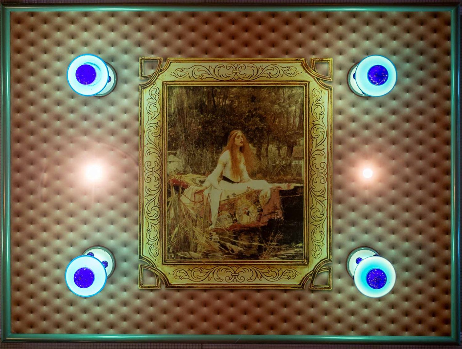 Vintage artwork in ornate gold frame mounted on textured wall with four glowing blue LED lights at the corners.