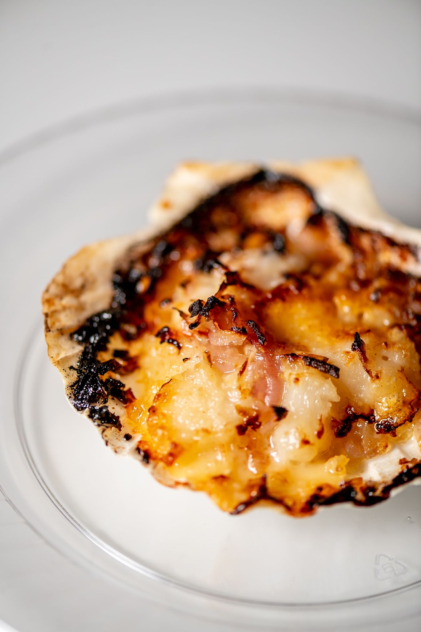 Grilled chicken with charred edges and caramelized glaze served on a white plate.