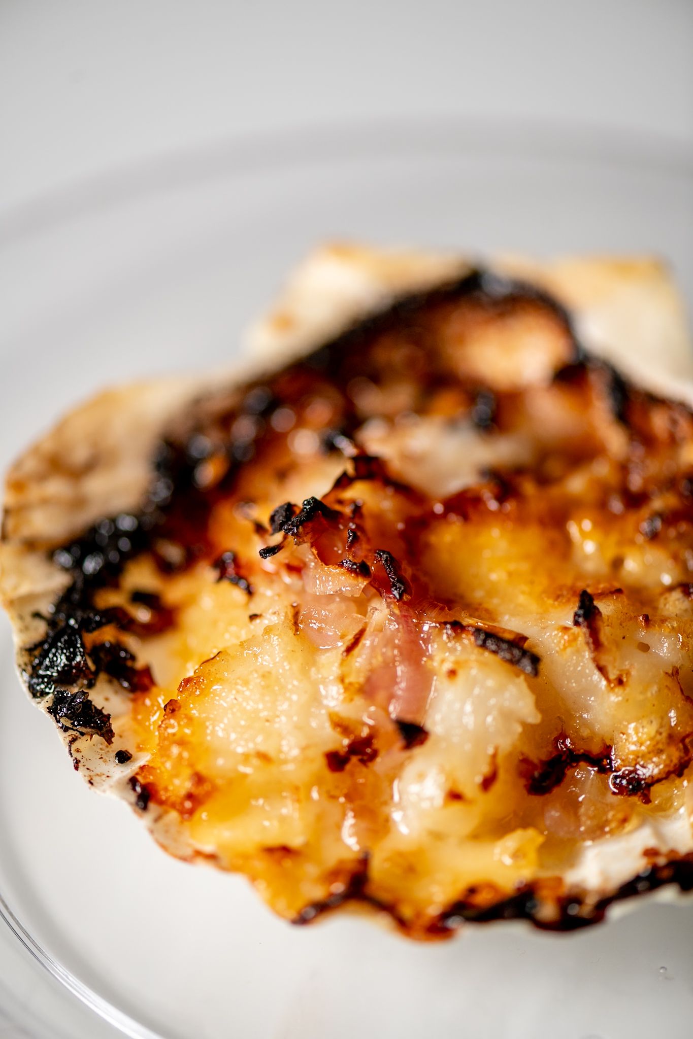 Grilled chicken with caramelized edges and charred marks on a white plate.