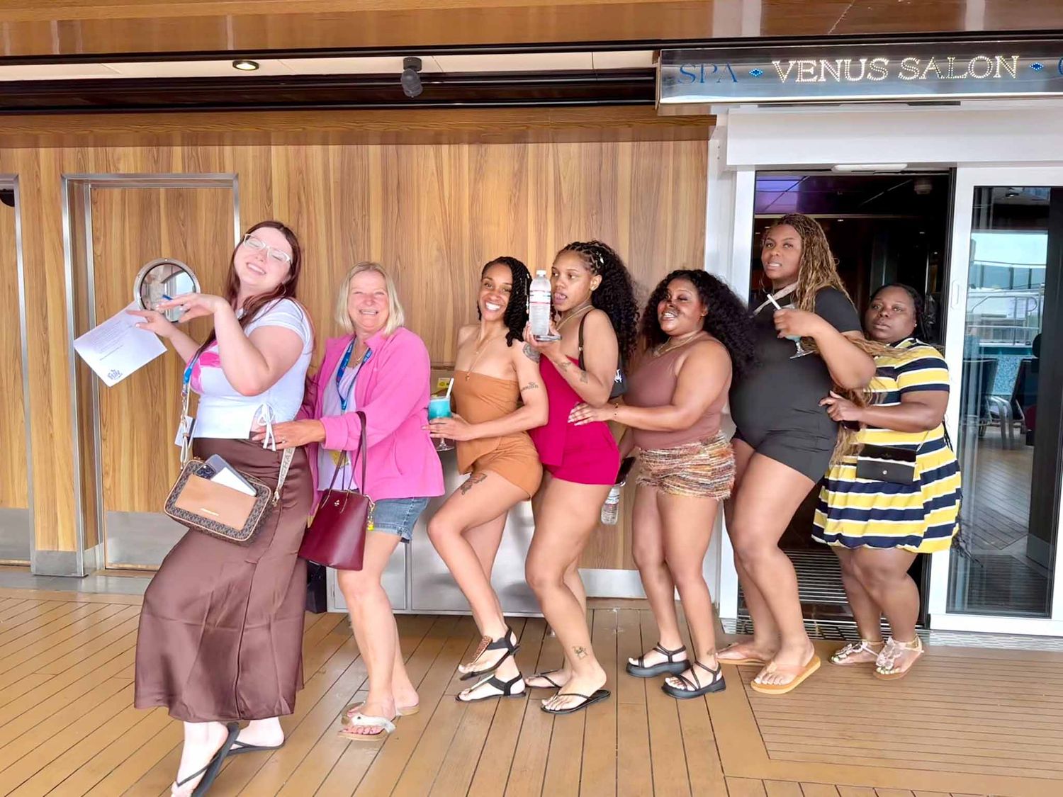 A group of people in a conga line dance through a hallway outside a salon.