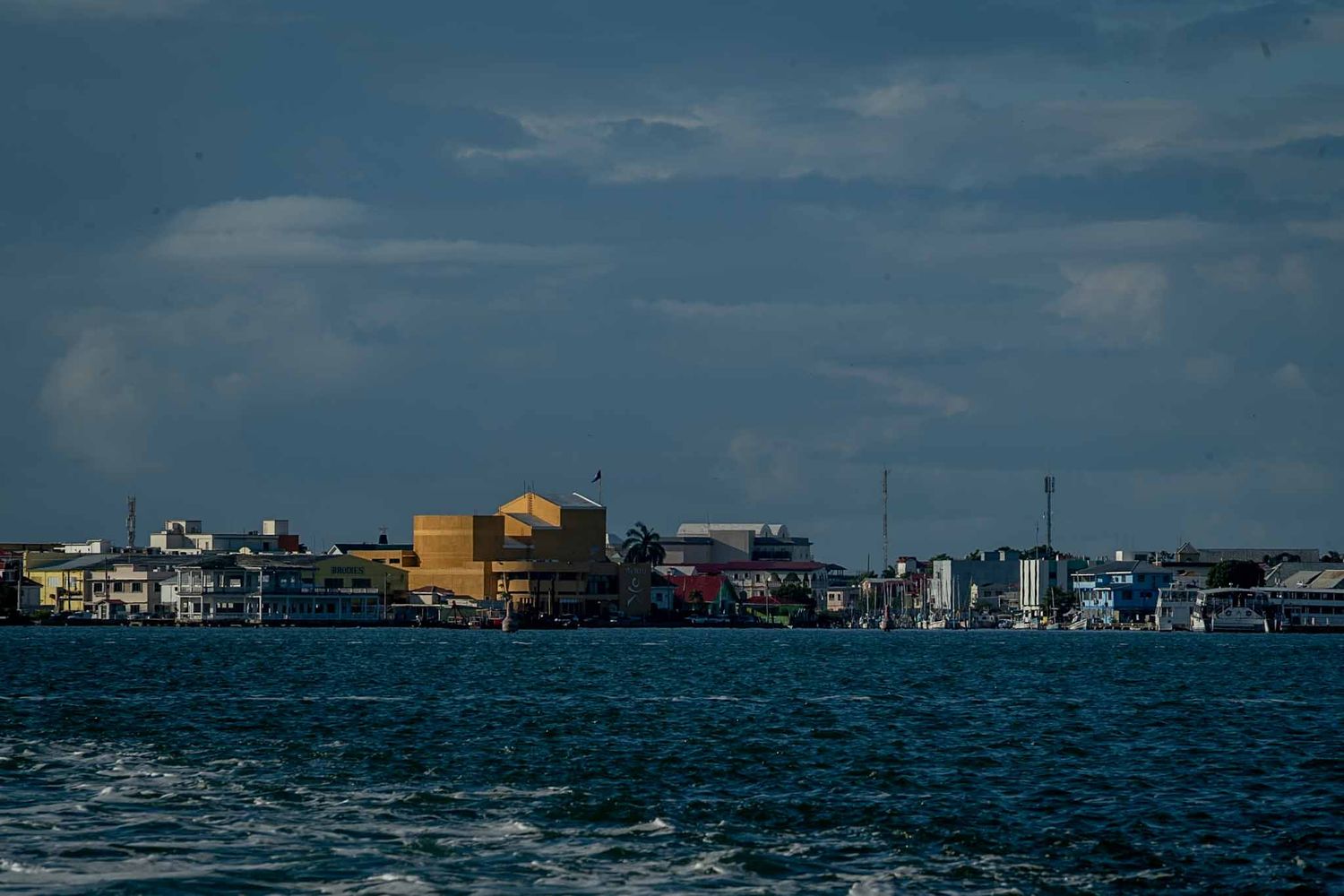A panoramic view of coastal buildings and waterfront stretching along the horizon under a blue sky.