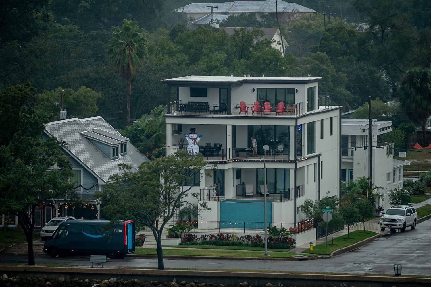 Row of modern white coastal houses on a hillside with contemporary architectural design.