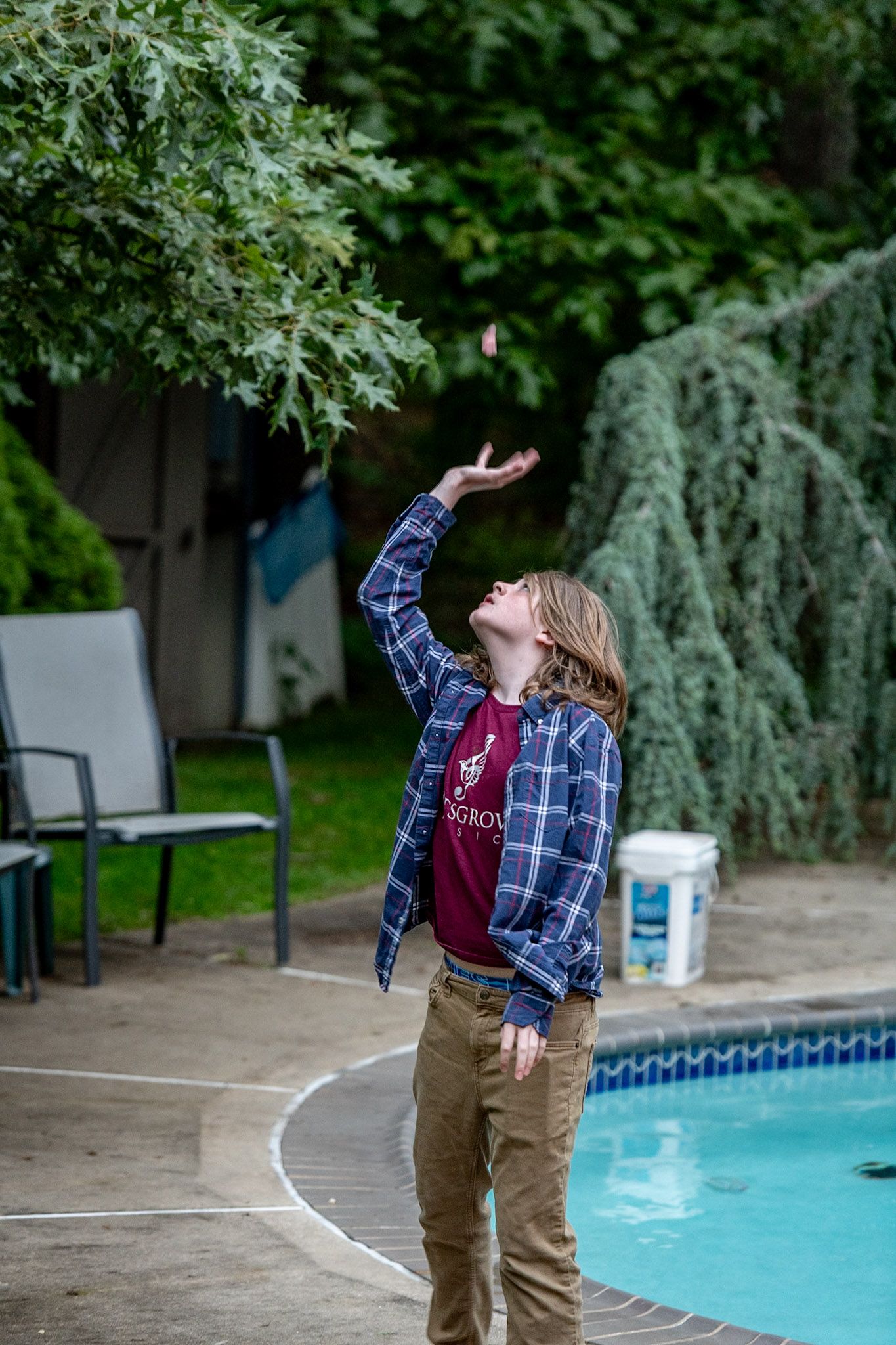 A child playing near a swimming pool during an outdoor gathering.