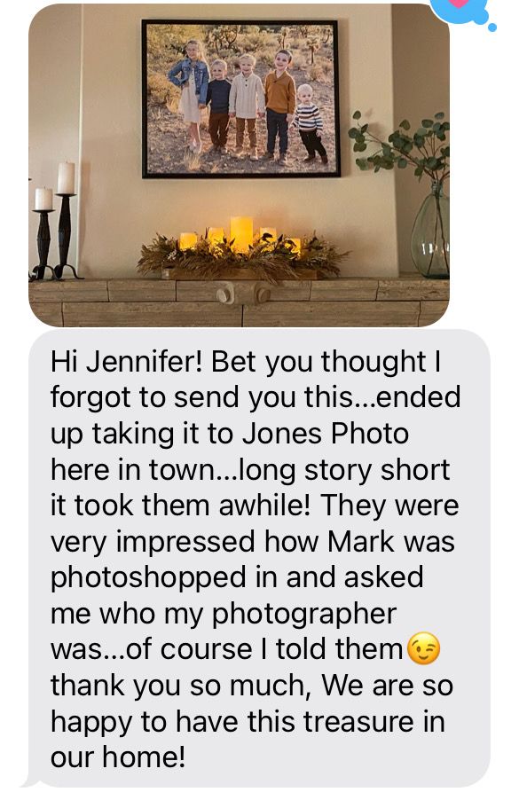 Family portrait photo displayed on wall above fireplace mantel with candles and greenery decor.