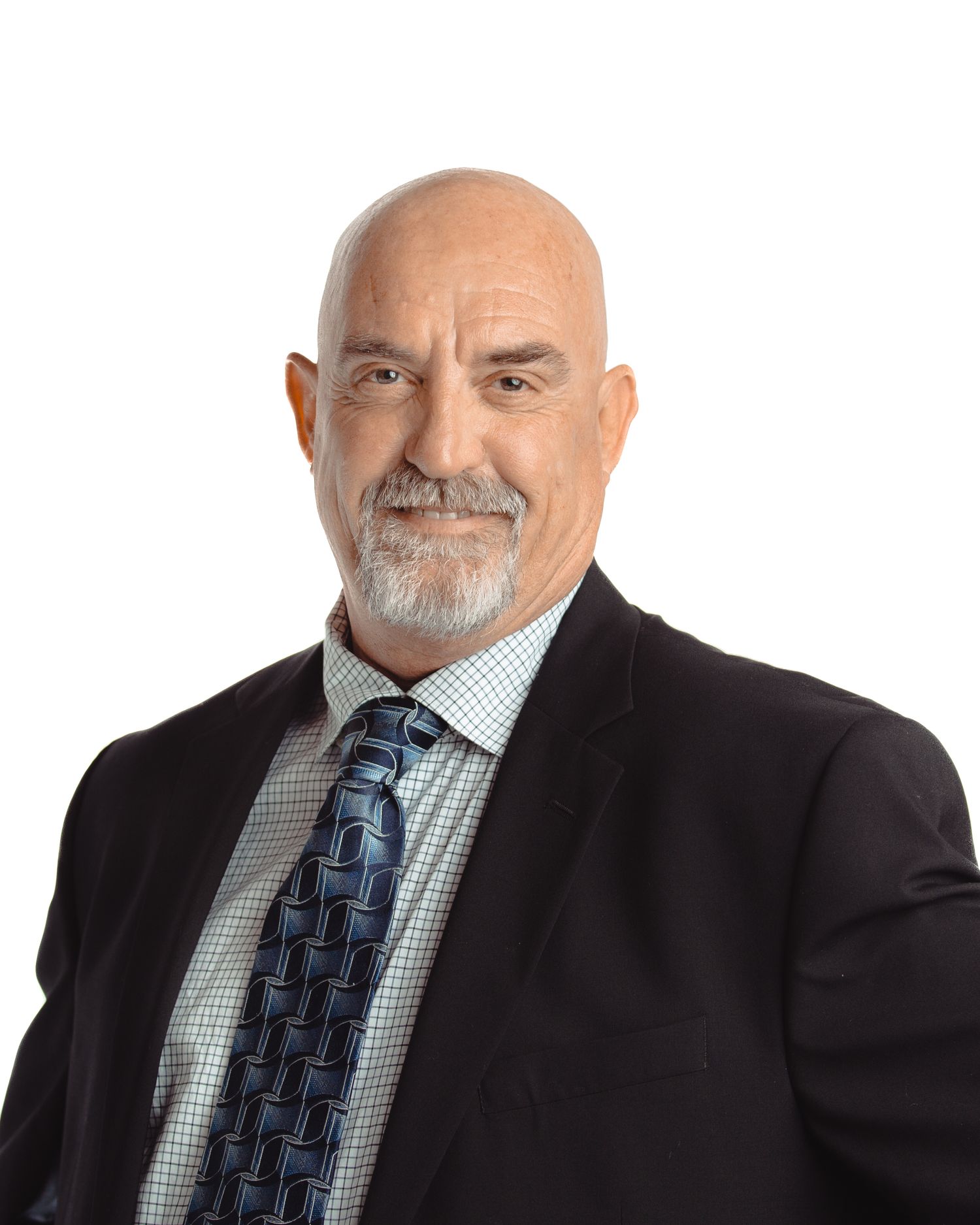 Bald professional man with gray goatee wearing a dark suit and blue patterned tie headshot.