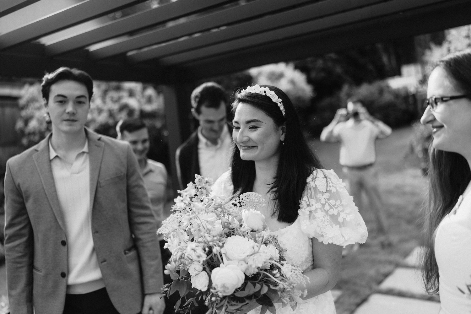 Black and white wedding party walking together outdoors in formal attire.
