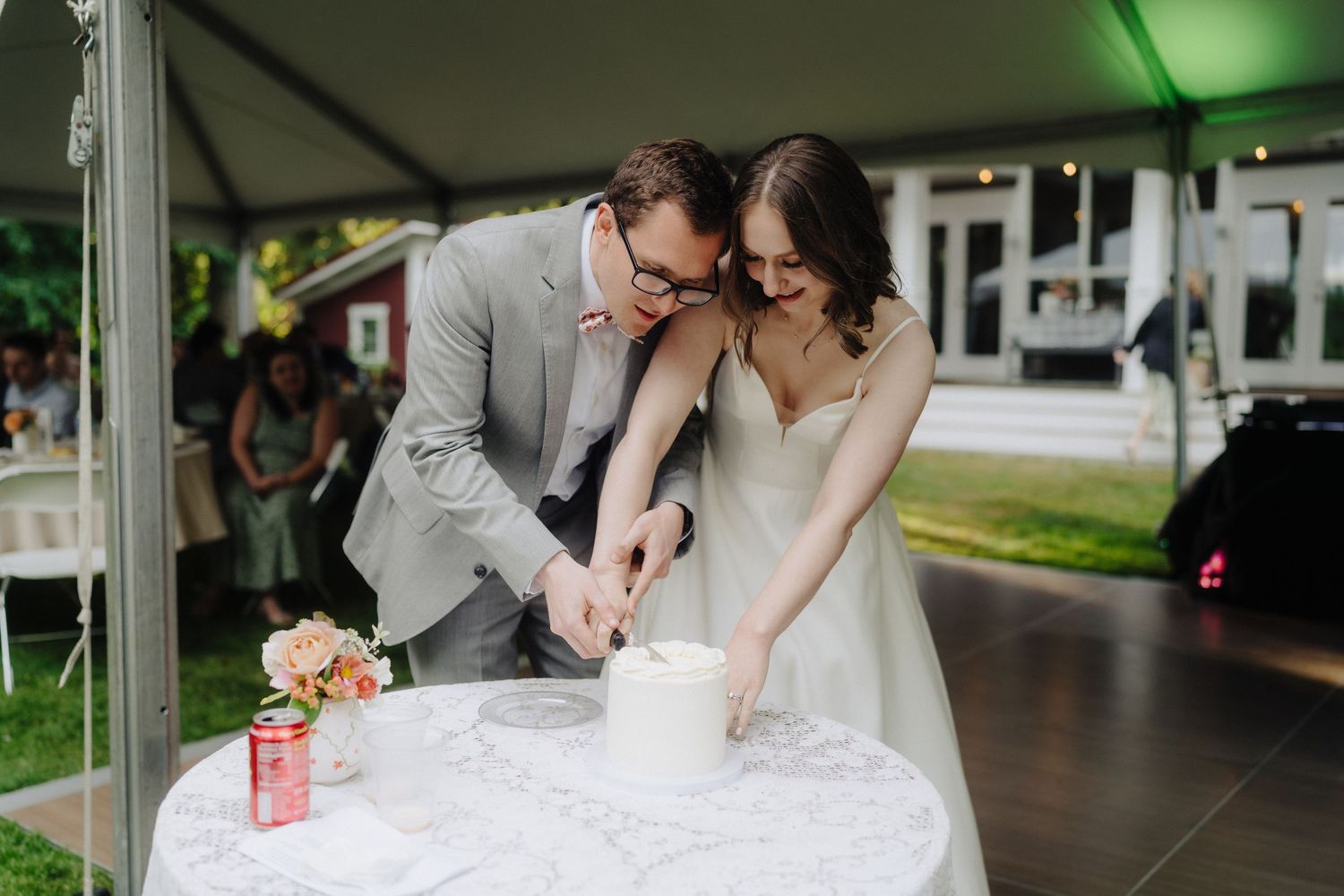 Wedding reception details under white tent with green lighting accents.