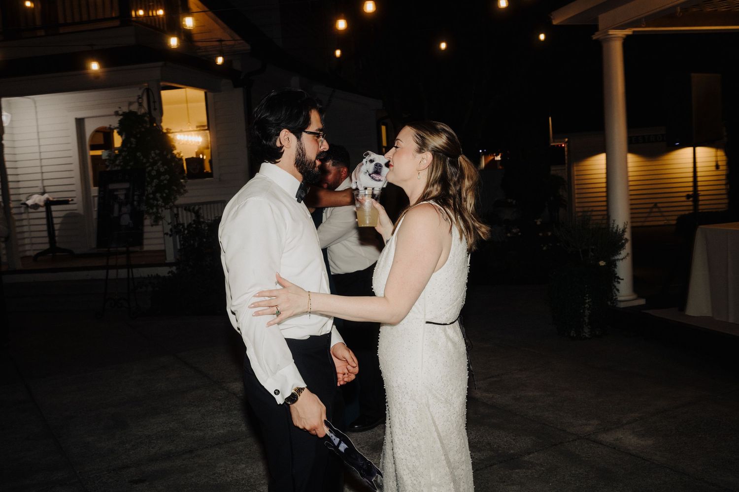 A romantic nighttime dance between a couple at an outdoor wedding reception.