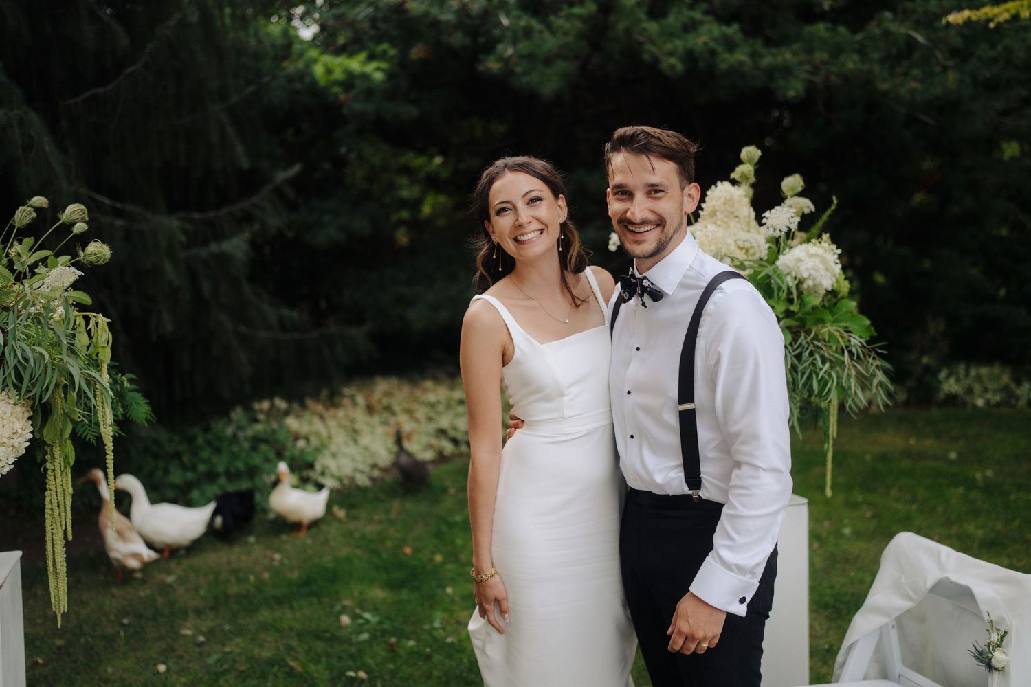 Outdoor garden wedding ceremony with elegant white floral arrangements and rustic decor.
