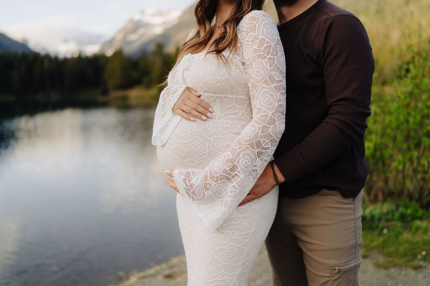 Intimate couple photography session by a scenic mountain lake during sunset.