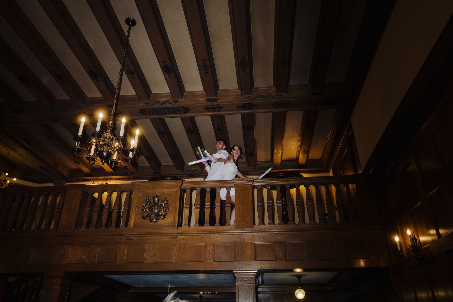 Wedding celebration in a rustic venue with exposed wooden beams and dramatic lighting.